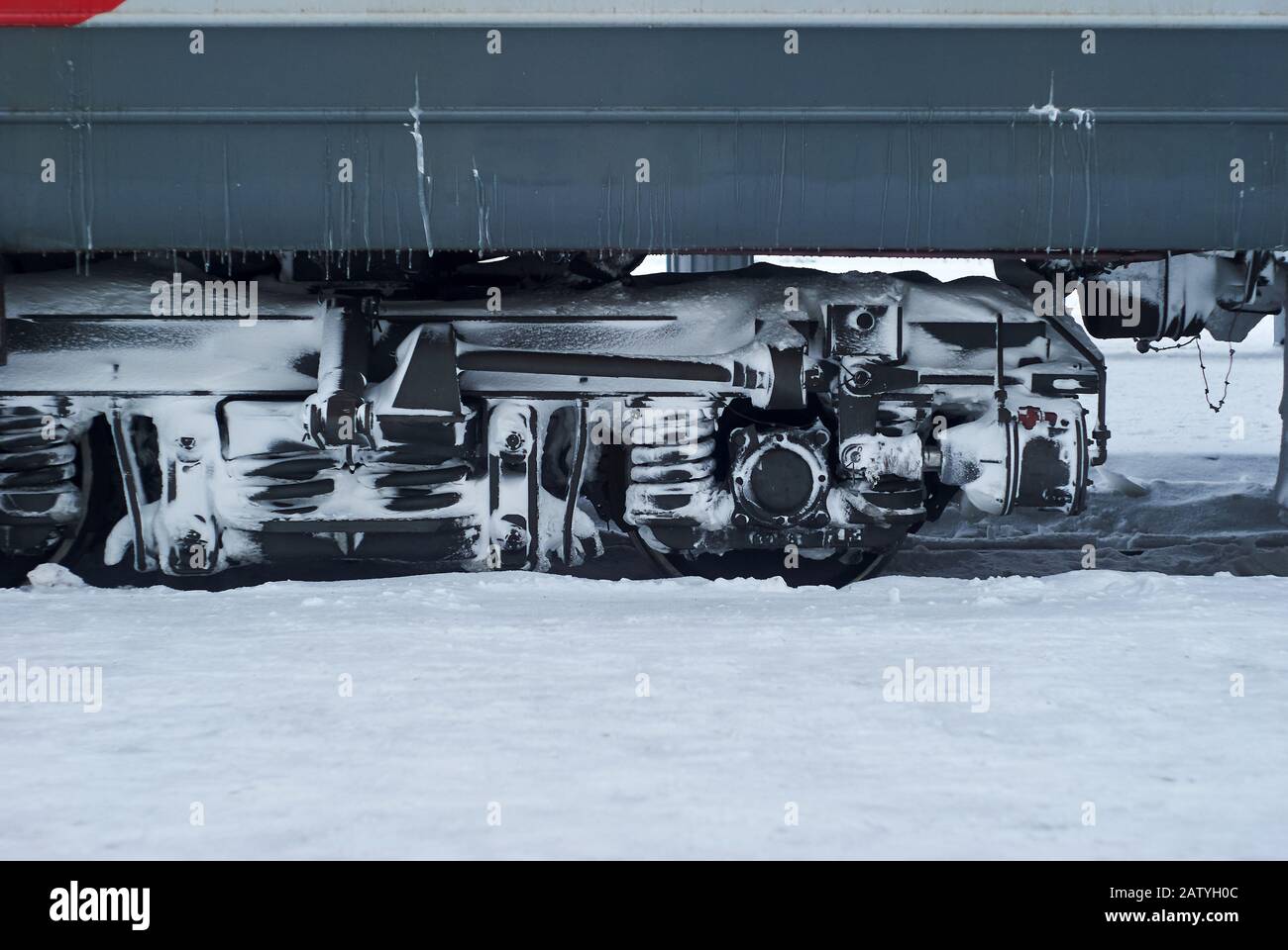 carrello coperto da ghiaccio e neve di un trasporto ferroviario di passeggeri su rotaie durante il funzionamento in inverno Foto Stock