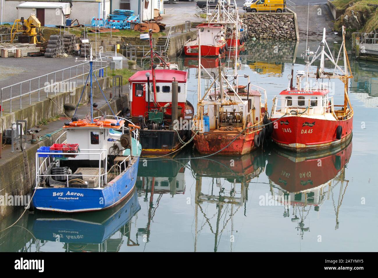 Piccole barche da pesca dai colori vivaci ormeggiate in una tranquilla giornata nel porto interno di Port Oriel sulla costa orientale dell'Irlanda nella contea di Louth. Foto Stock