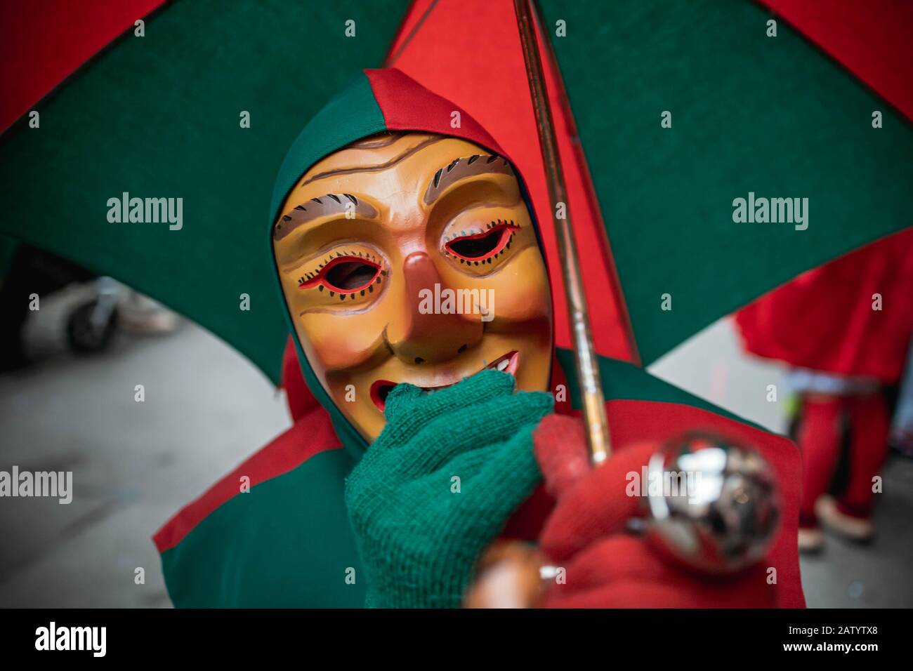 Oberwindemer Spitzbue - Fastnachts Fool con ombrello tiene la mano sopra la bocca. Sfilata di Carnevale a Staufen, Germania meridionale. Foto Stock