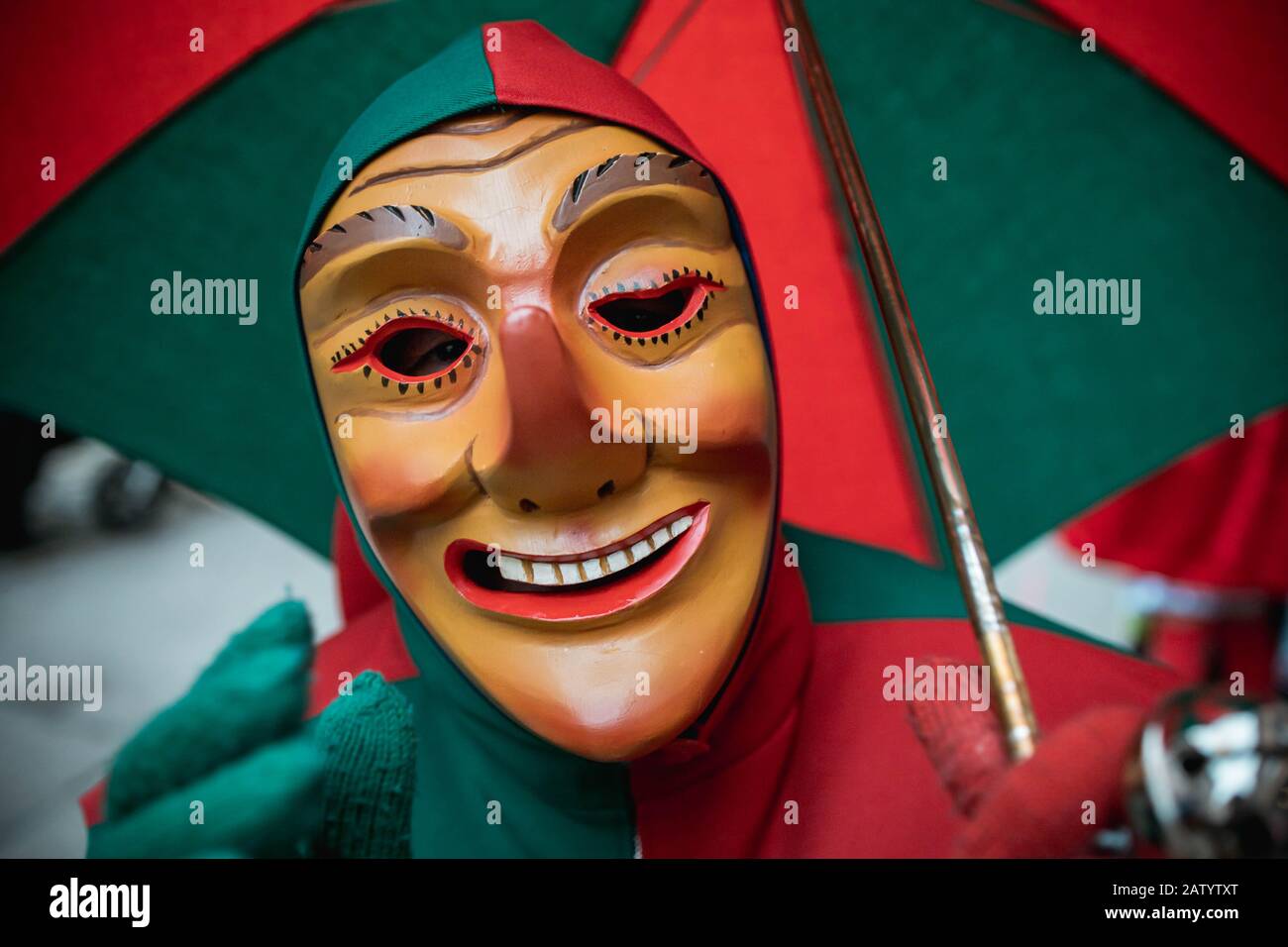 Oberwindemer Spitzbue - sciocco di Carnevale con grande bocca e ombrello durante la sfilata di Carnevale a Staufen, Germania meridionale. Foto Stock