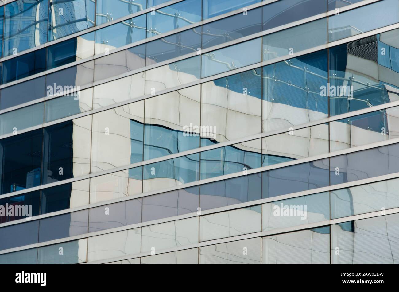 Edificio riflettente in cui si riflettono quelli circostanti. Immagine di linee parallele e perpendicolari in toni bluastri. Puerto Madero, Buenos Aire Foto Stock