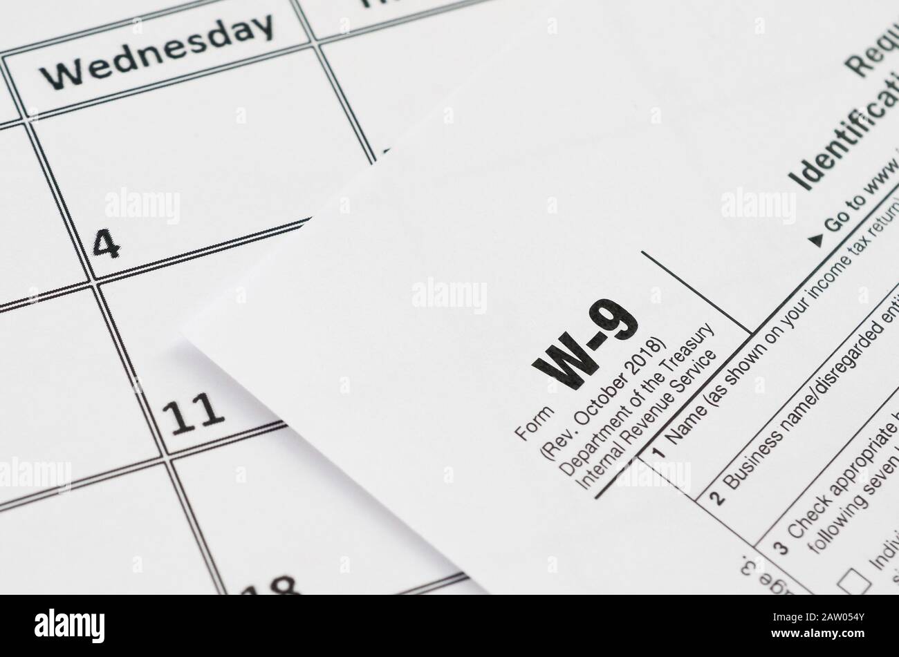 IRS Form W-9 richiesta per il contribuente un numero di identificazione e certificazione giace vuoto sul vuoto nella pagina del calendario. Periodo fiscale concetto. Copia spazio per il testo Foto Stock