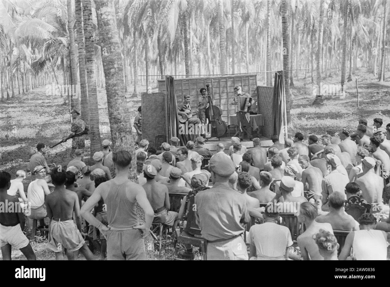 [Spettacolo musicale all'aperto. Del chitarrista, bassista e fisarmonicista. Il pubblico è composto da soldati] Data: 1946 luogo: Indonesia Indie orientali olandesi Foto Stock