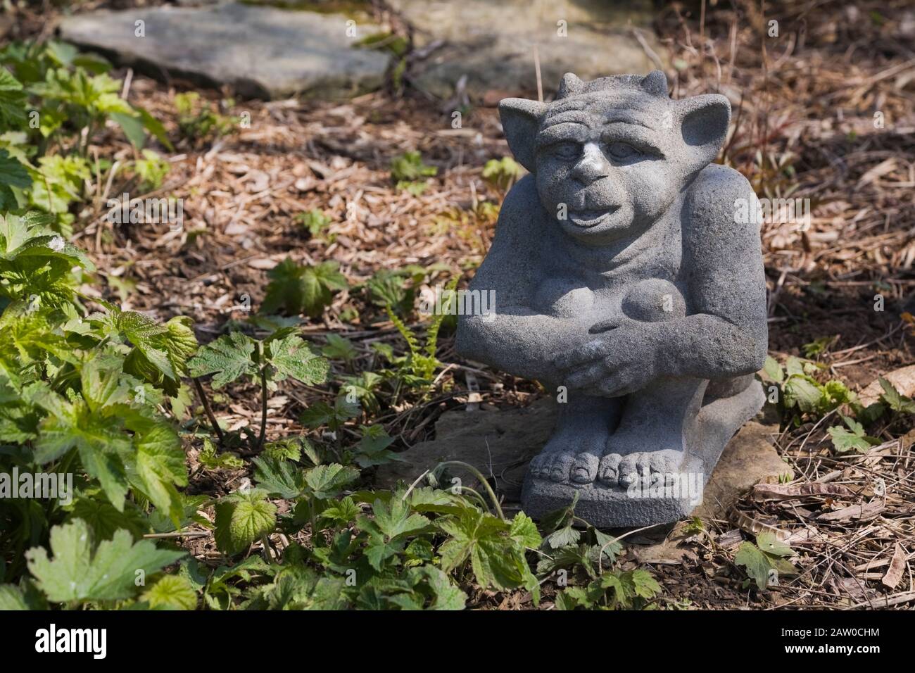 Primo piano di una piccola statua di gargoyle giardino cortile in primavera. Foto Stock
