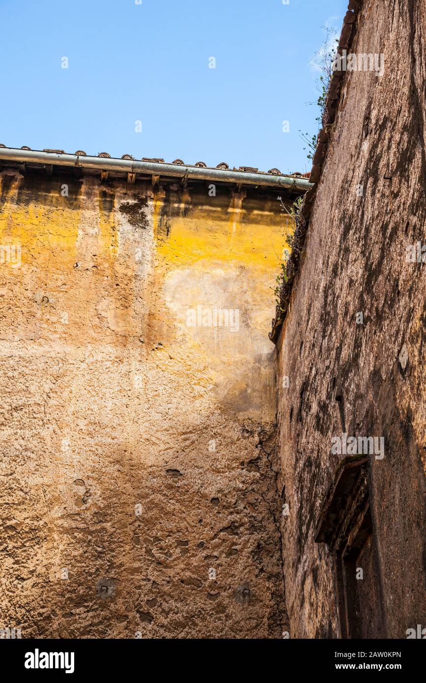 Mura testurizzate e dorate di colore giallo nel quartiere Trastevere di Roma. Foto Stock