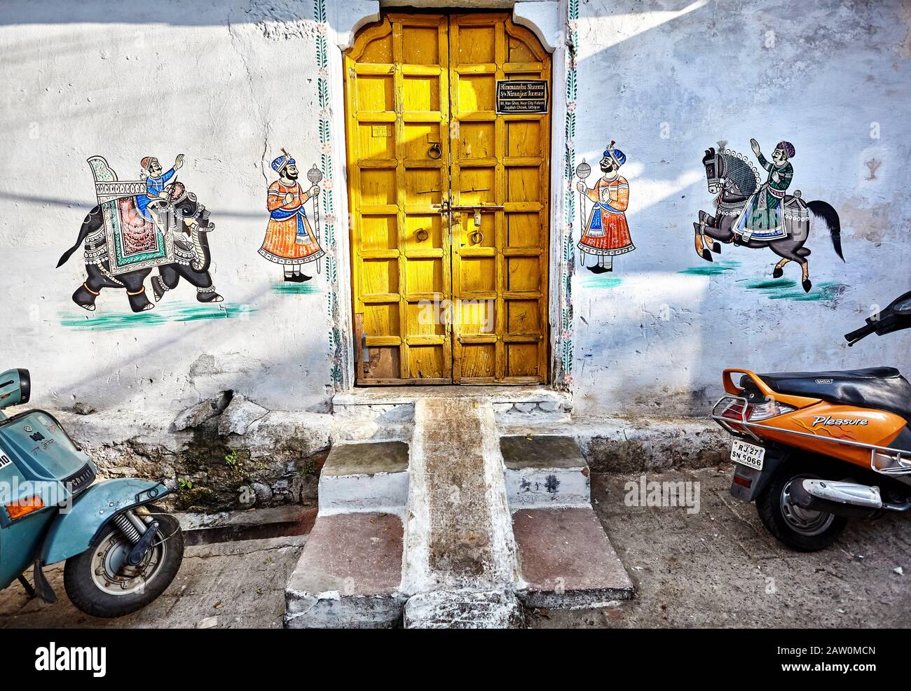 Udaipur, RAJASTHAN, INDIA - 03 MARZO 2015: Bei Dipinti di Maharaja su elefante e cavallo al muro di casa con porta gialla nella città di Udaipur. Foto Stock