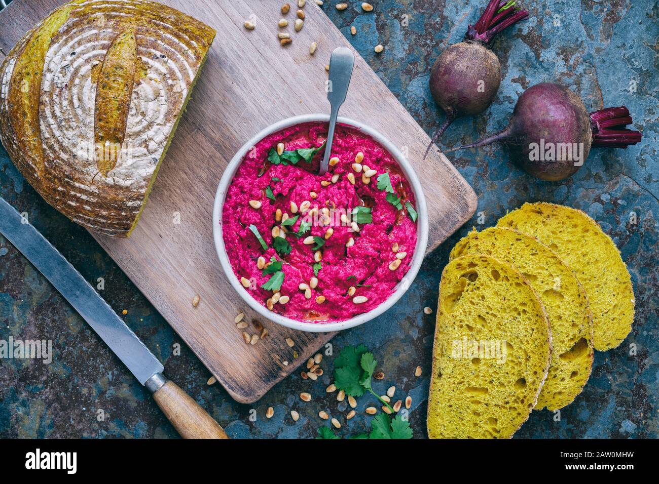 Hummus di barbabietola arrostito fatto in casa e pane di pasta turmerica su uno sfondo di ardesia Foto Stock