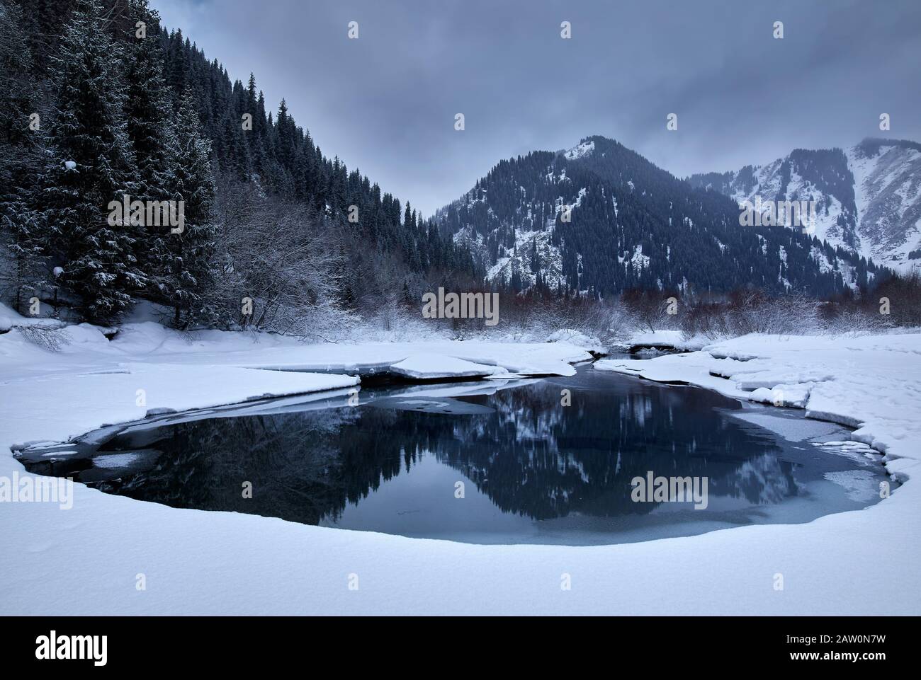Bellissimo paesaggio di montagne invernali riflesso al lago Issyk in Kazakistan. Foto Stock