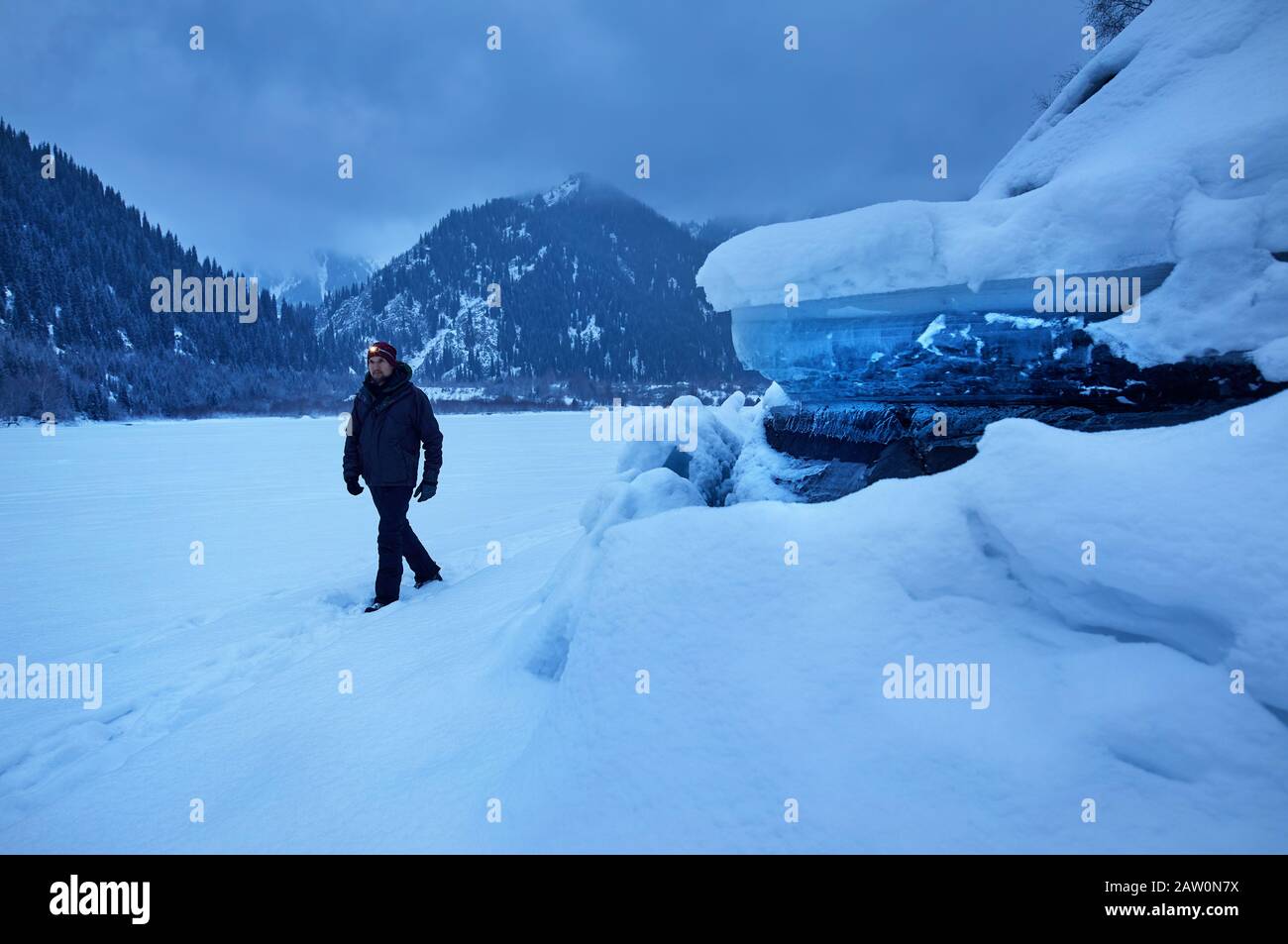 Turistico con faro è a piedi al lago ghiacciato con grande formazione di ghiaccio in inverno. Foto Stock