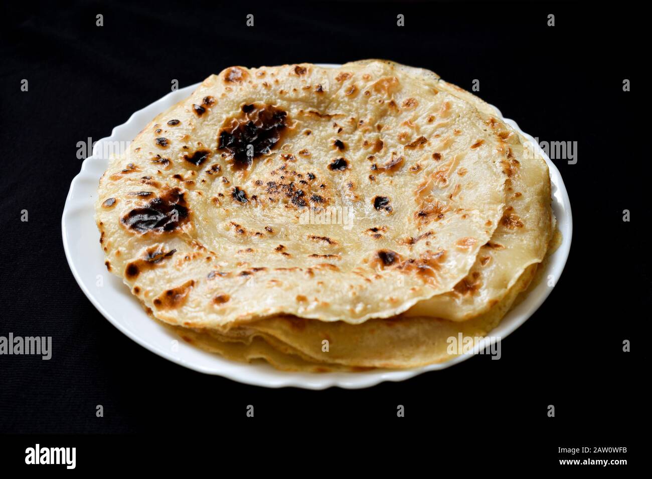 un piatto di tradizionale pane piatto di gente somala su uno sfondo scuro Foto Stock