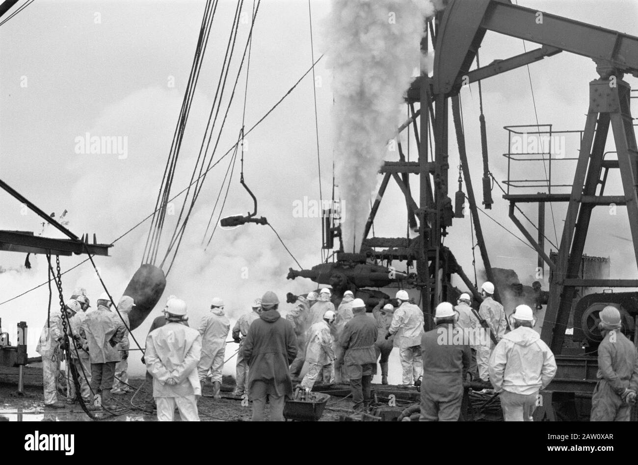 Fontana dell'olio a Schoonebeek (Drenthe); i tecnici si occupano di visualizzare la massa dell'olio in uscita verso l'alto e di tentare la valvola Data di applicazione: 9 novembre 1976 posizione: Drenthe, Schoonebeek Parole Chiave: Olio Foto Stock
