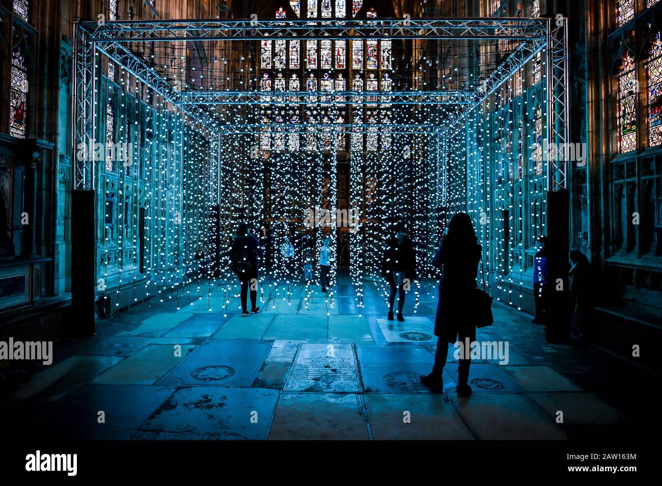 La gente guarda 'Dove c'è la luce' opere d'arte installate nella Lady Chapel presso la Cattedrale di Gloucester, che consiste di centinaia di luci individuali che mimano i colori di un arcobaleno, durante una narrazione e musica, progettato da un gruppo di arti digitali, Squidminestra. Foto Stock