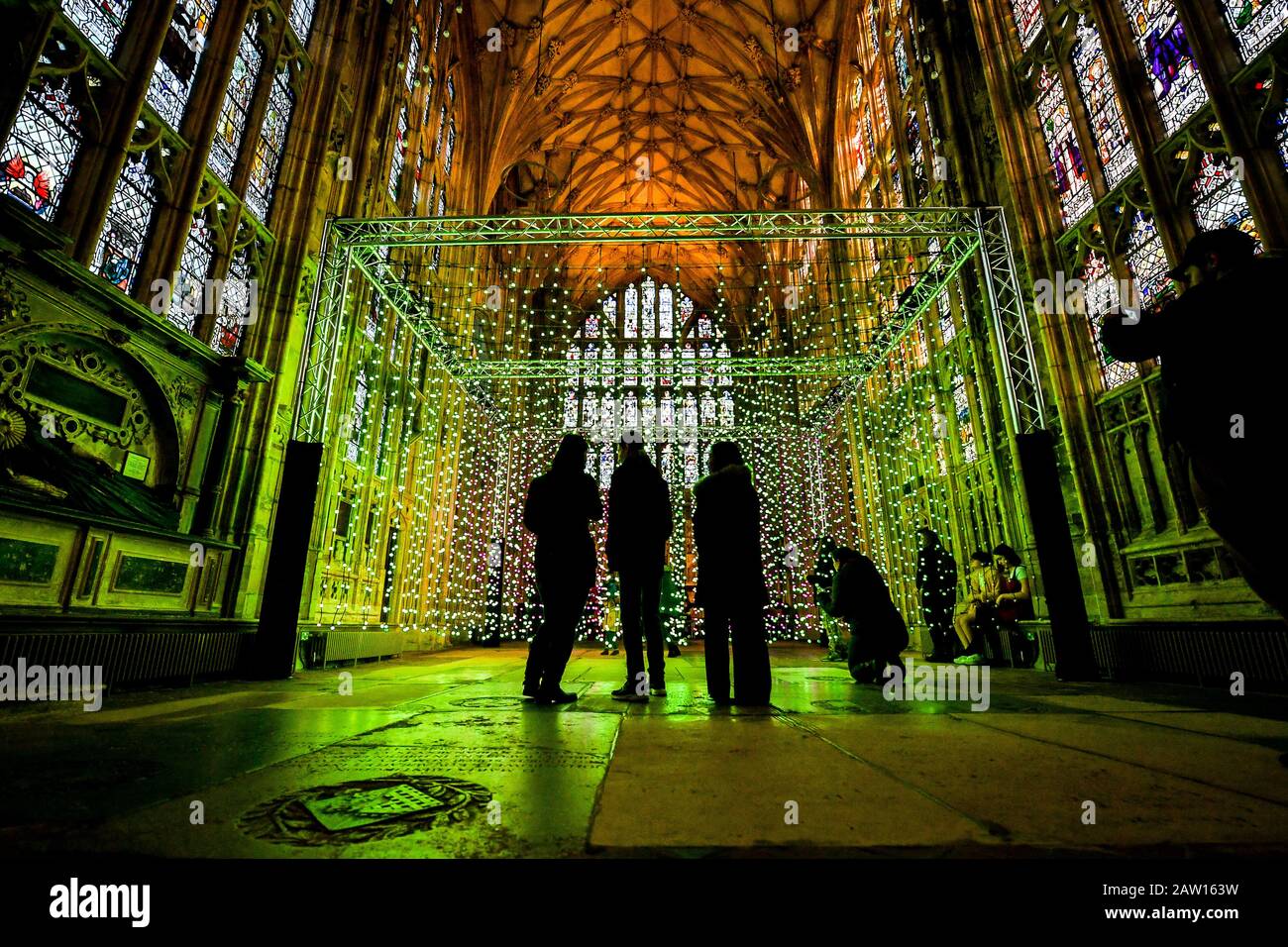 La gente guarda 'Dove c'è la luce' opere d'arte installate nella Lady Chapel presso la Cattedrale di Gloucester, che consiste di centinaia di luci individuali che mimano i colori di un arcobaleno, durante una narrazione e musica, progettato da un gruppo di arti digitali, Squidminestra. Foto Stock