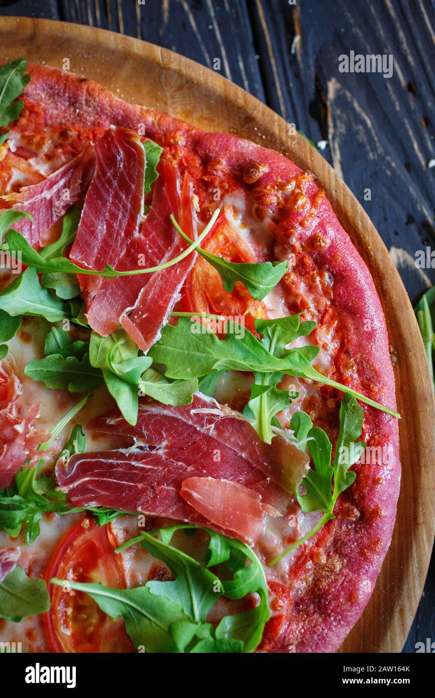 Gustosa e appetitosa pizza classica italiana tradizionale. Concetto per un pasto gustoso e sostanzioso. Sfondo rustico in legno. Foto Stock