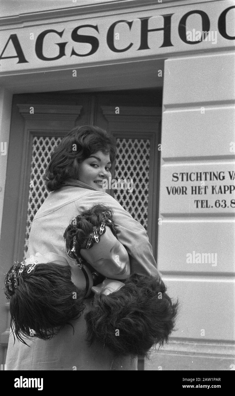 Apertura della prima kappersdagschool alla Principessa Marieke Street all'Aia, uno degli studenti va su alcuni modelli all'interno / Data: 29 febbraio 1960 Località: L'Aia Sud Olanda Parole Chiave: Alunni, MODELLI, Aperture, kappersdagscholen Foto Stock