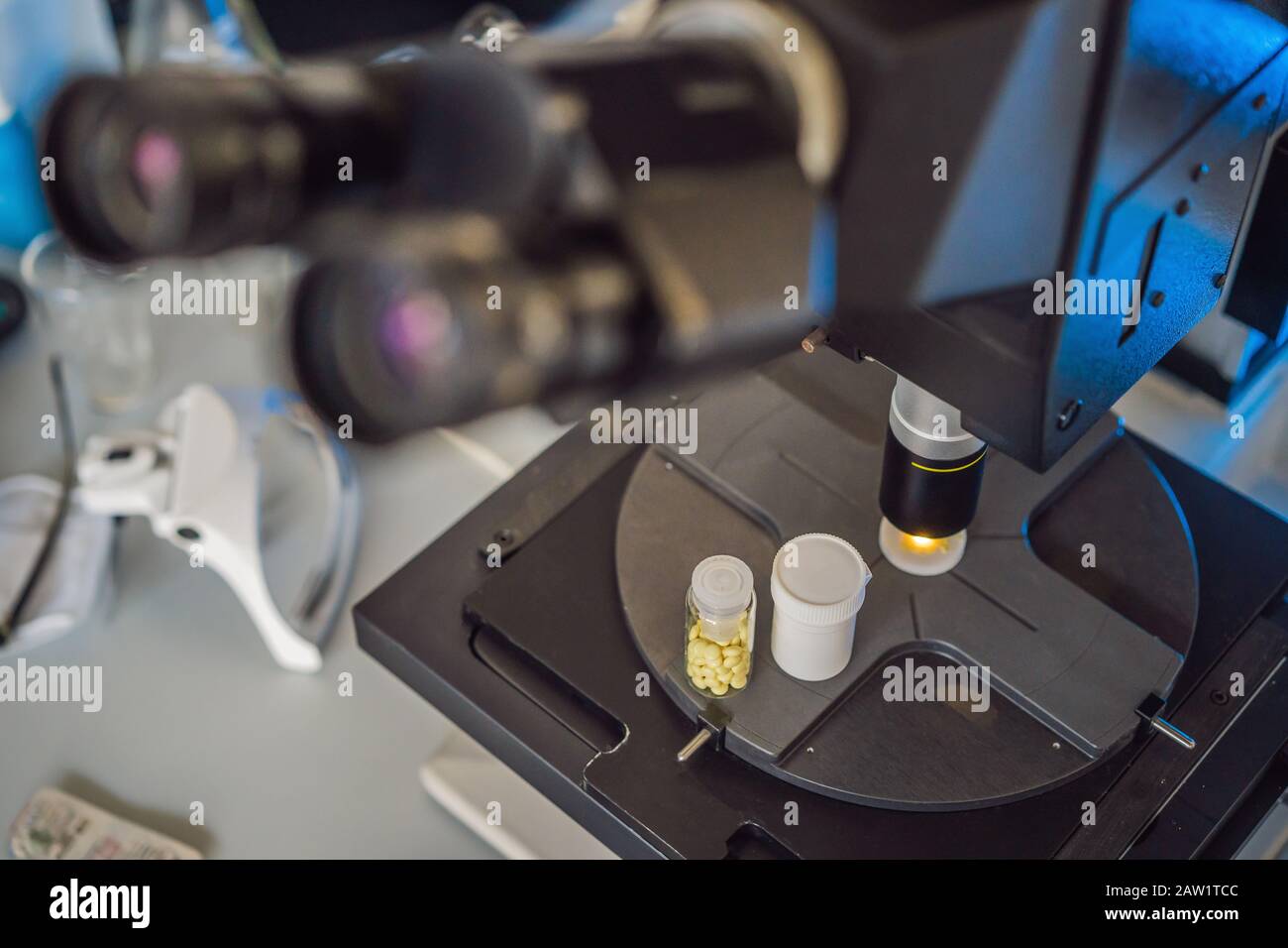 Ricerca di laboratorio scientifico sicuro di nuovi farmaci, microscopio e pillole coronavirus Foto Stock