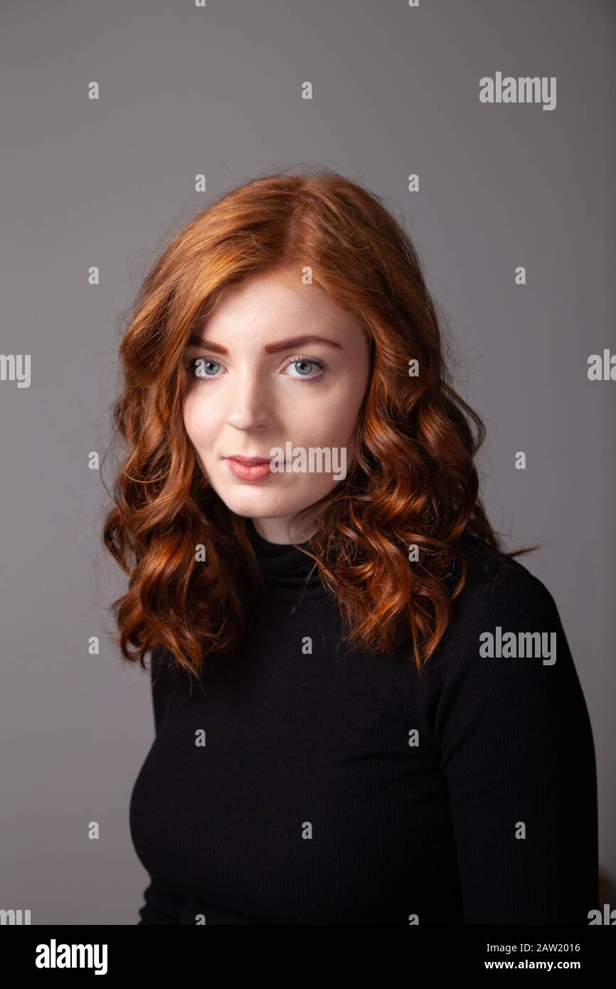 Ritratto di una bella donna con testa rossa che guarda verso la fotocamera. Foto Stock