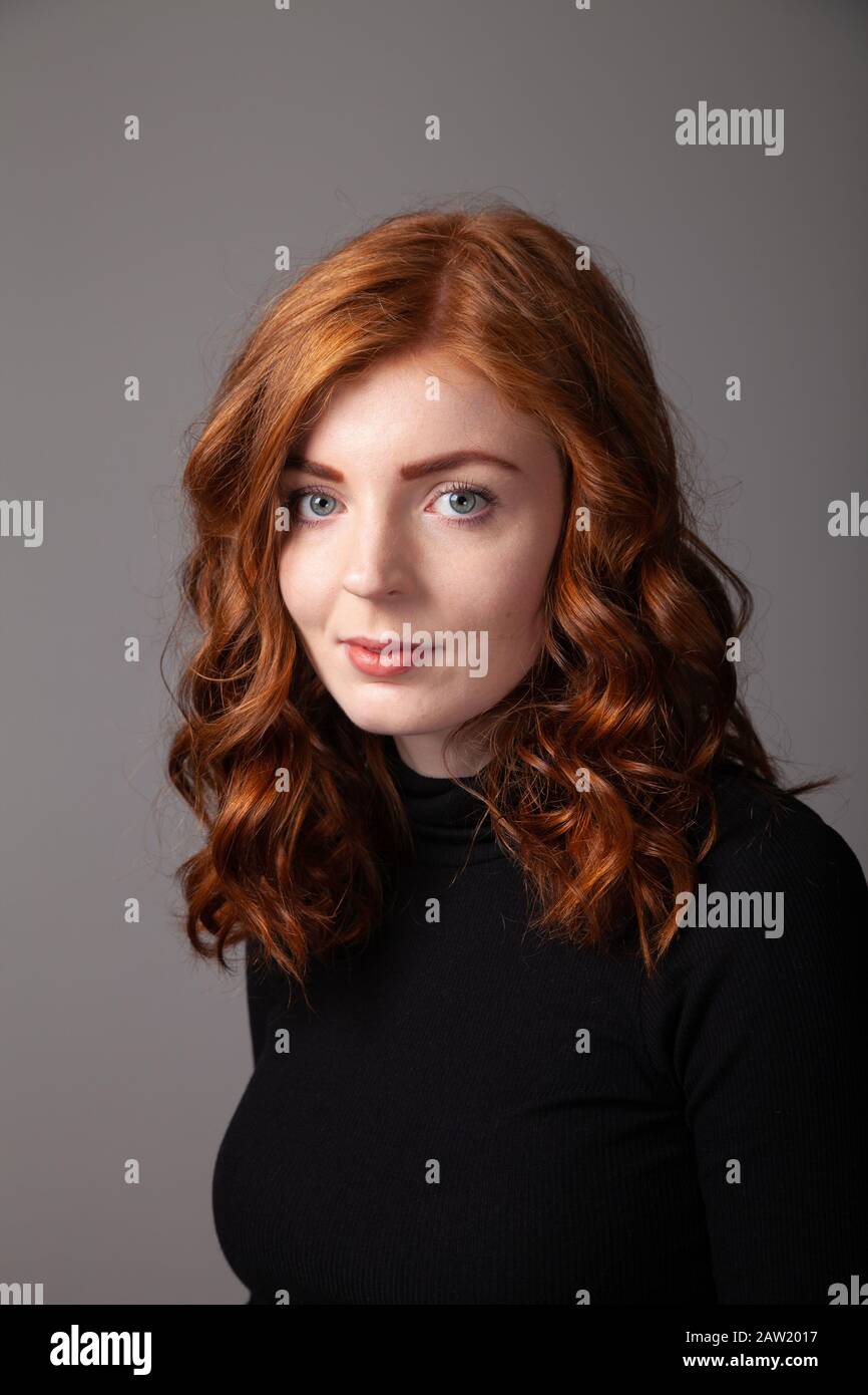 Ritratto di una bella donna con testa rossa che guarda verso la fotocamera. Foto Stock