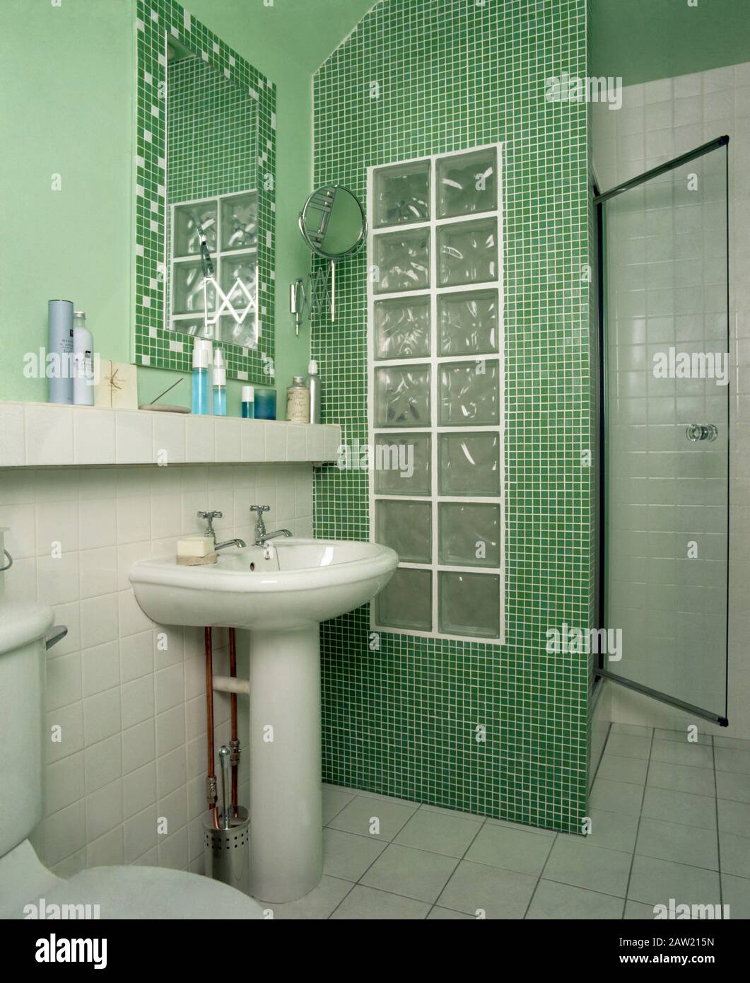 Lavello accanto a mosaico sullo schermo la doccia in una economia verde bagno di stile Foto Stock