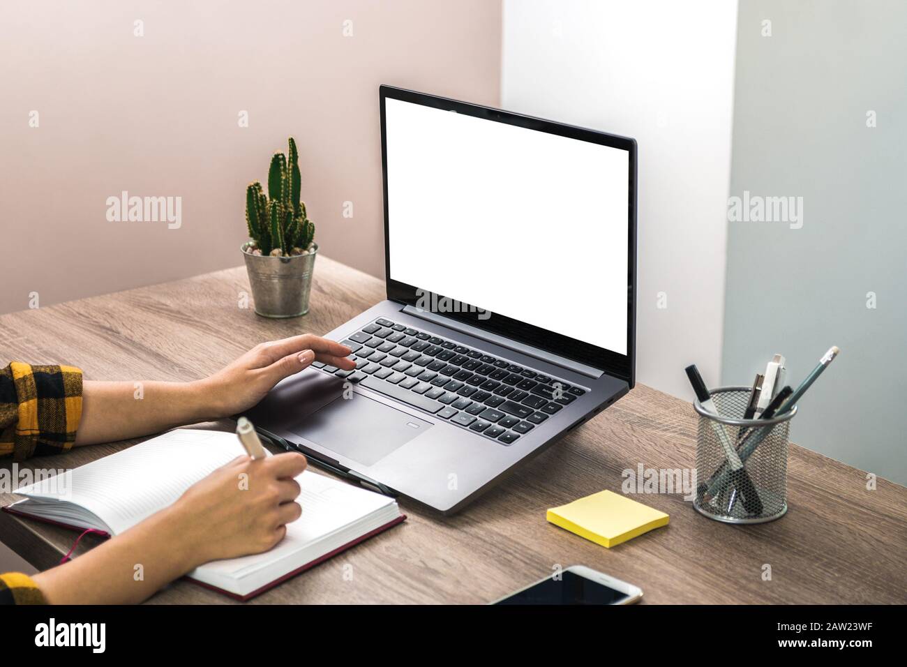 mani ravvicinate di una donna d'affari, uno studente o un freelancer in camicia gialla e schermo bianco sul laptop. ufficio moderno Foto Stock