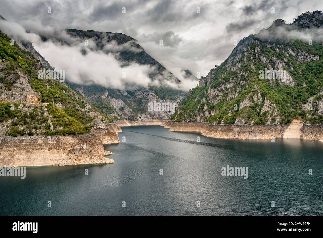 Nuvole basse, pioggia, sopra il lago di Piva (Pivsko jezero) con basso livello d'acqua, lago artificiale sul fiume Piva nel canyon di Piva, vicino a Pluzine, Montenegro Foto Stock