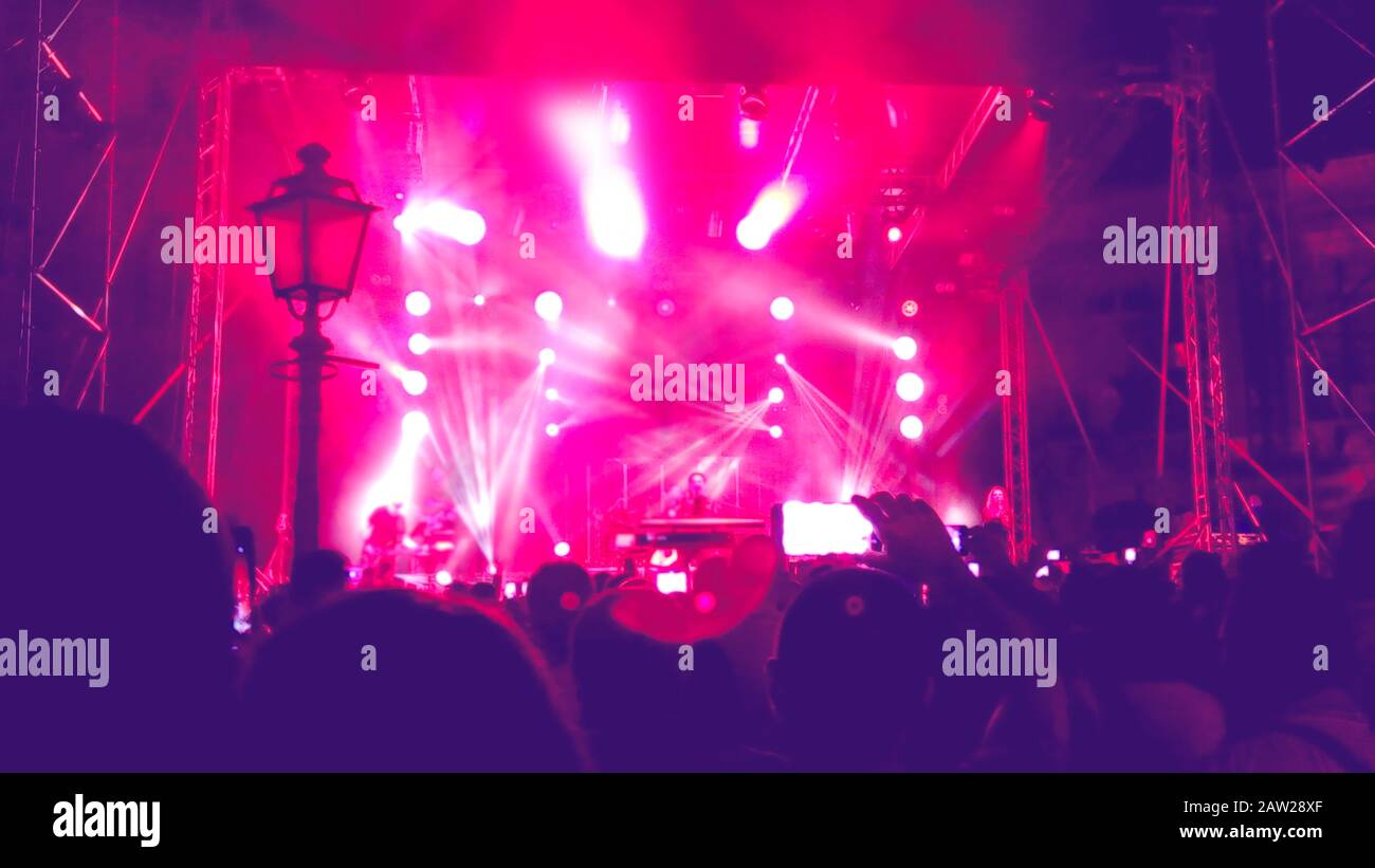 concerto rock, sfondo di variopinti faretti di rosso rosa colorato e vivace palcoscenico Foto Stock