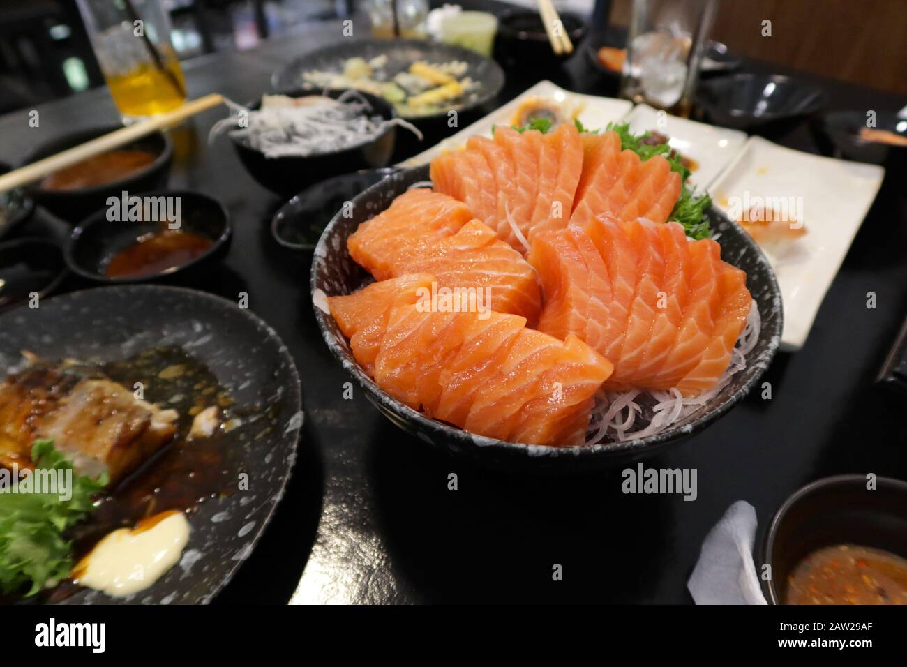 Vista ravvicinata di deliziosi sushi, sashimi di salmone crudo su piatto nel ristorante giapponese. Foto Stock