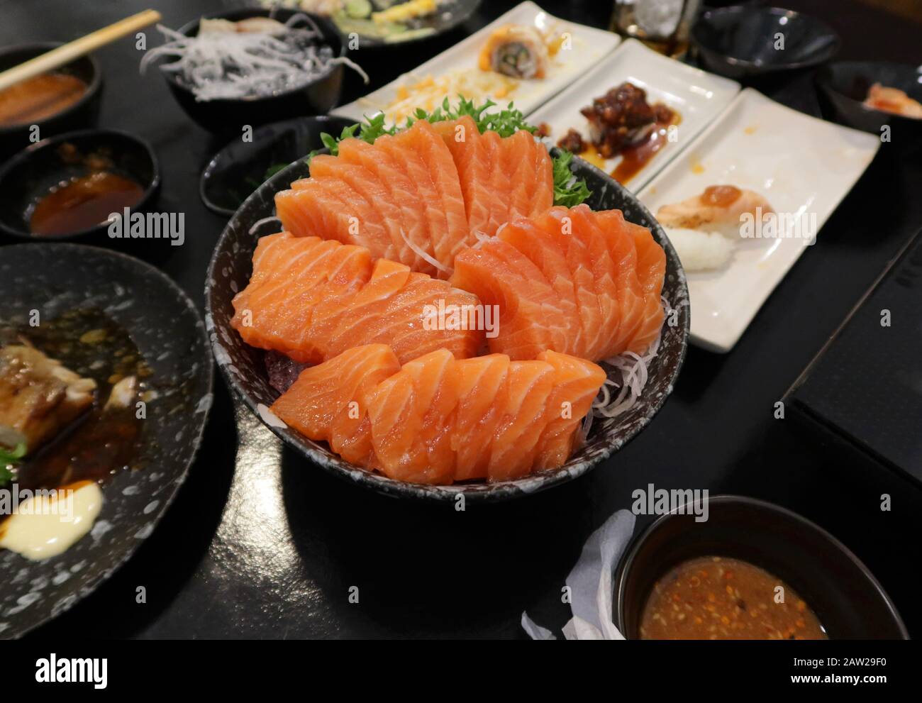 Vista ravvicinata di deliziosi sushi, sashimi di salmone crudo su piatto nel ristorante giapponese. Foto Stock