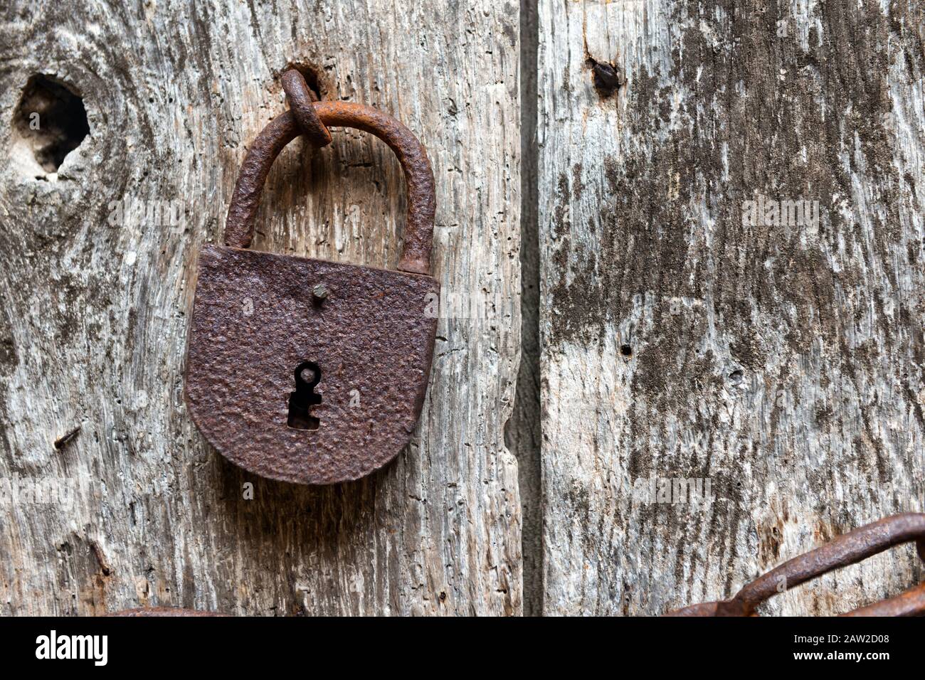vecchio arrugginito chiuso serratura su un antico porta di legno Foto Stock