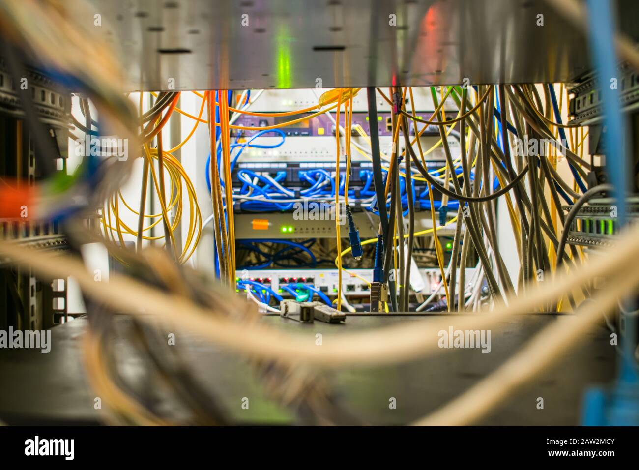 Molti fili sono nel rack con l'apparecchiatura di commutazione del provider Internet. I cavi di comunicazione e i cavi patch in fibra ottica si trovano nella Foto Stock
