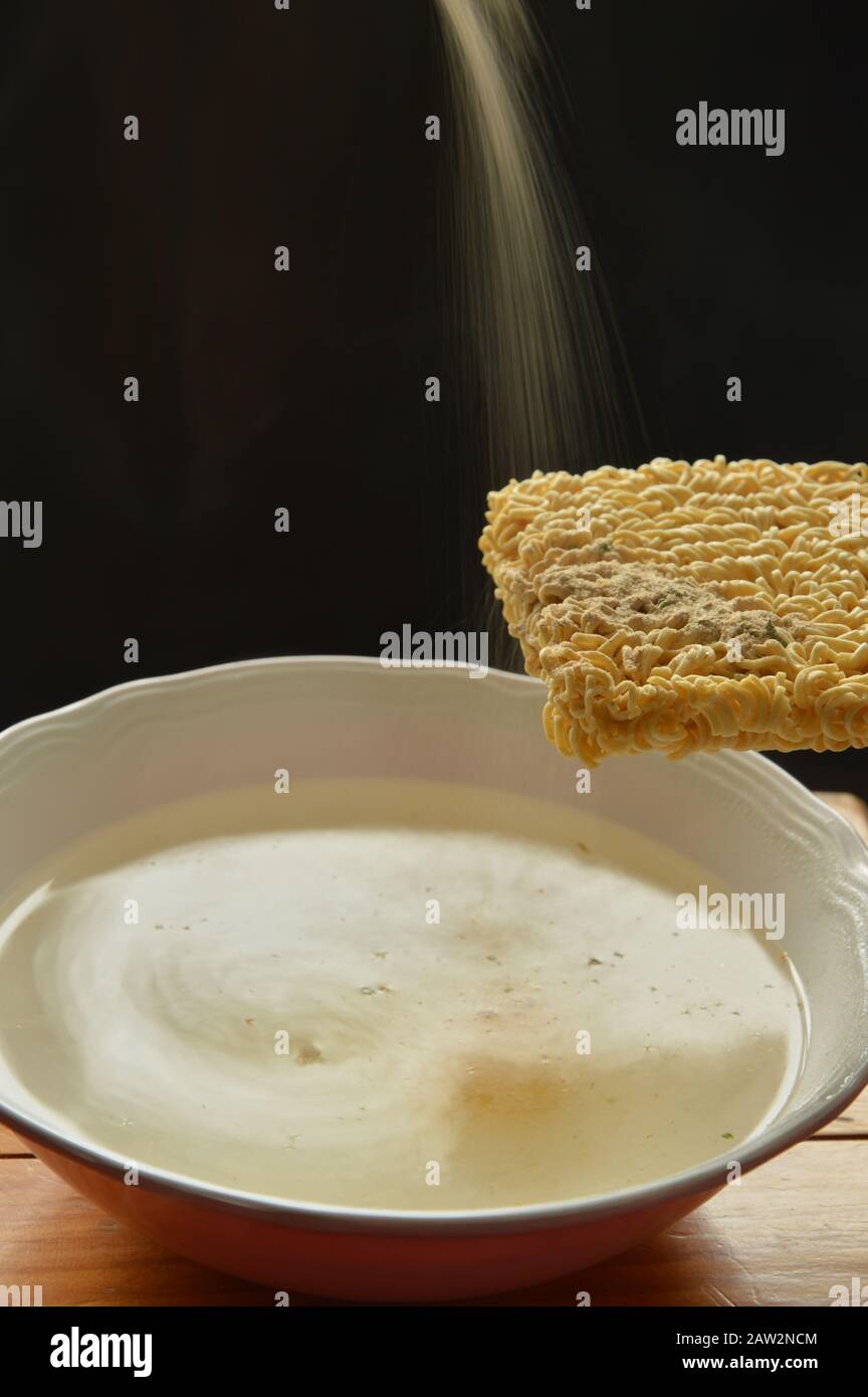 noodle istantanei che si gocciolano all'acqua calda con fumato sul piatto Foto Stock