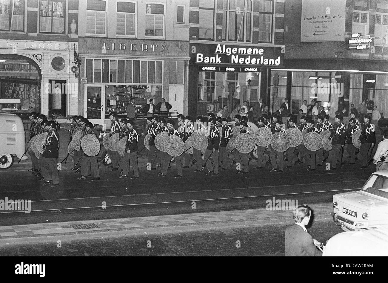 La polizia si esibisce ad Amsterdam con grande potenza sommossa, qui a Damrak Assistance plotone di polizia militare armato di bastone e scudo Data: 16 giugno 1966 Località: Amsterdam, Noord -Holland Parole Chiave: Polizia militare, sommossa Foto Stock