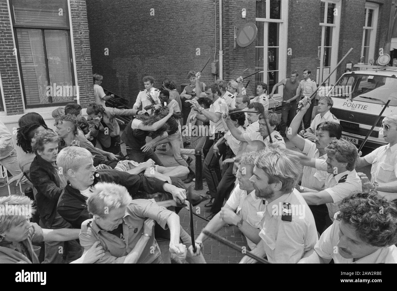 Polizia inseguisce i manifestanti di distanza contro il partito del centro del consigliere al municipio Amsterdam Data: 25 giugno 1986 luogo: Amsterdam, Noord-Holland Parole Chiave: Polizia, manifestanti, corridoi della città Persona Nome: Partito centrale Foto Stock