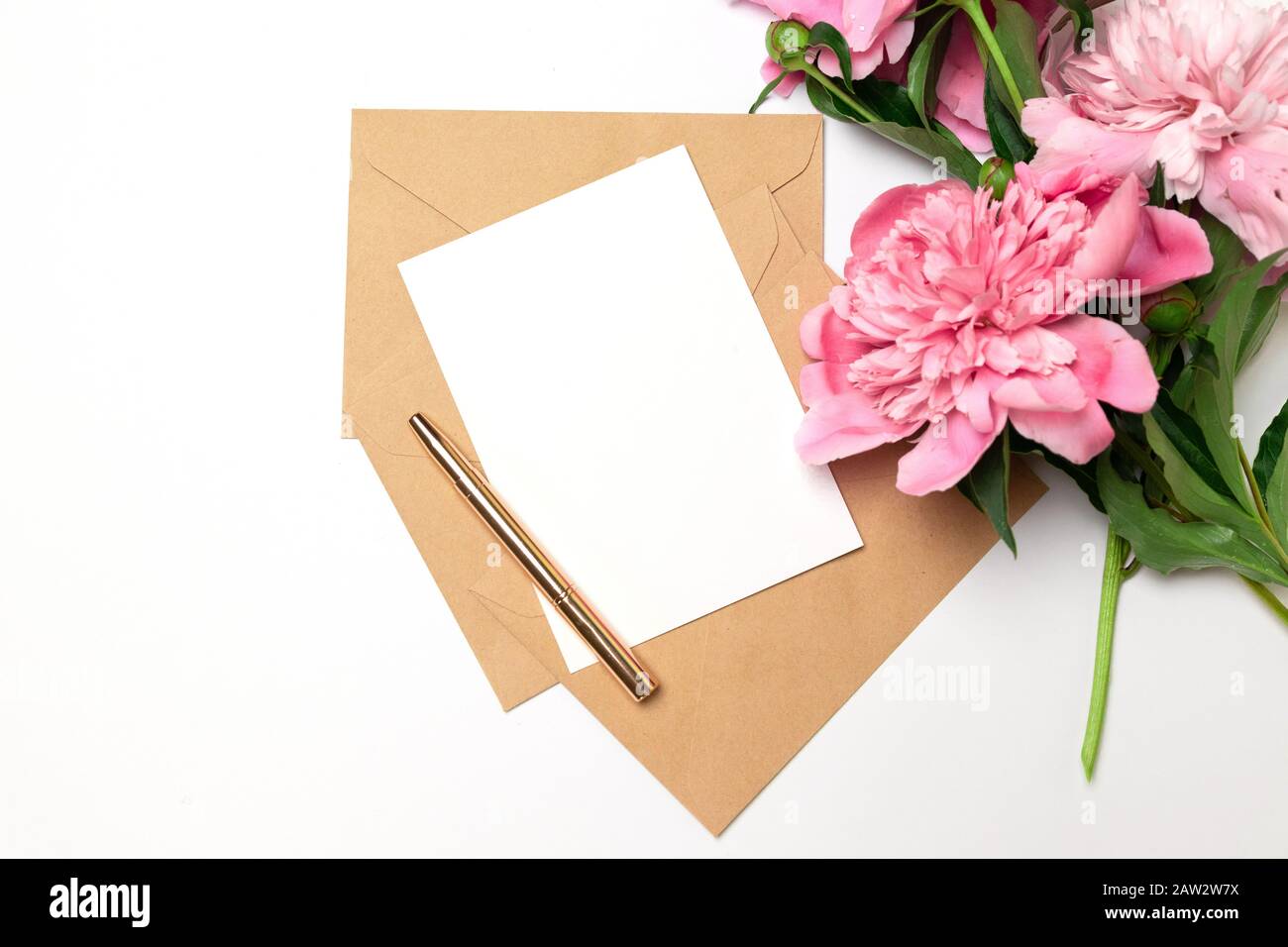 Biglietto d'auguri in busta Craft, penna d'oro con bouquet di peonie rosa su sfondo rosa per il compleanno, il giorno della madre o San Valentino Foto Stock