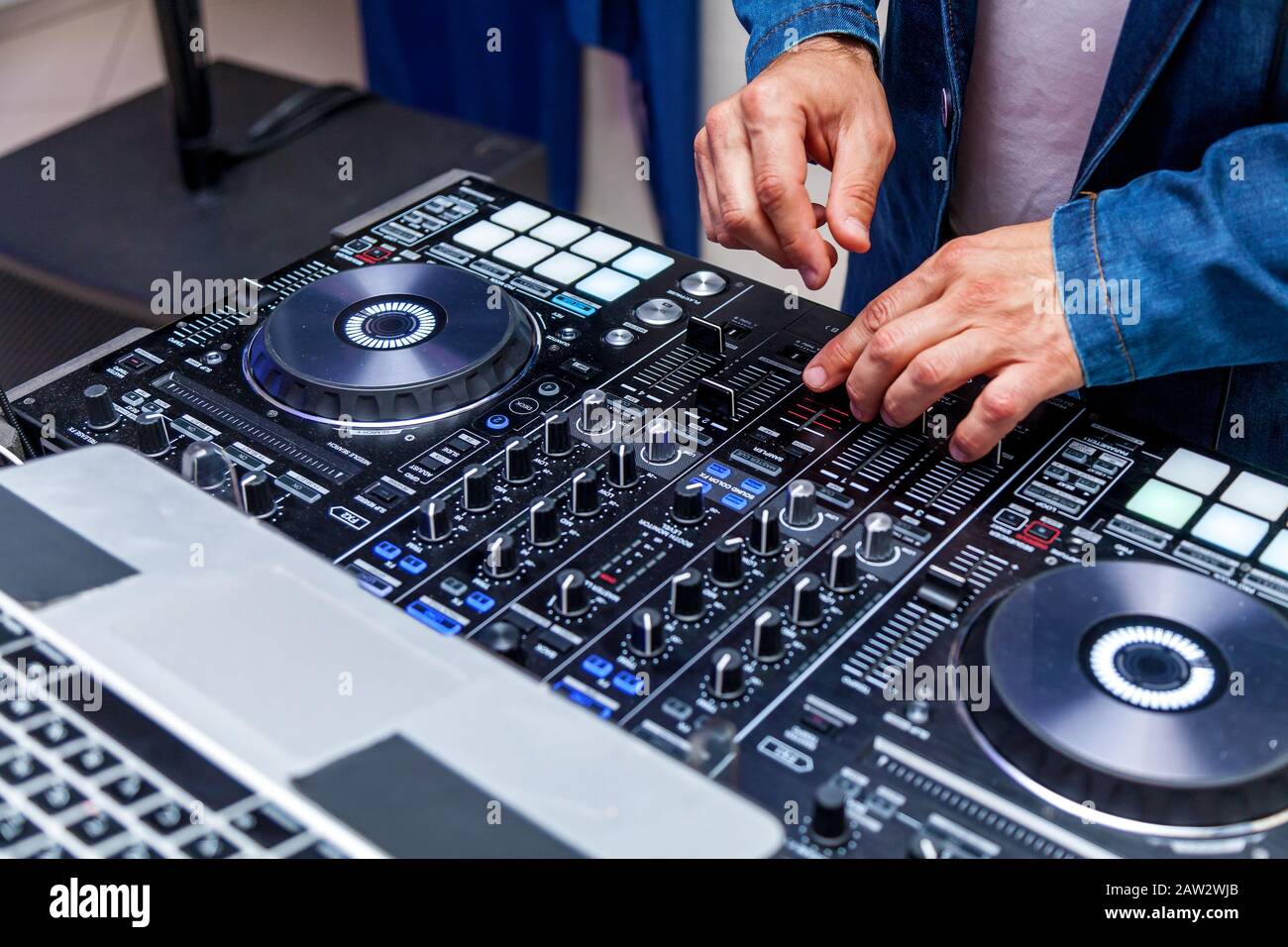 Un uomo che suona musica su un mixer audio e mixa brani al party sulla spiaggia Foto Stock