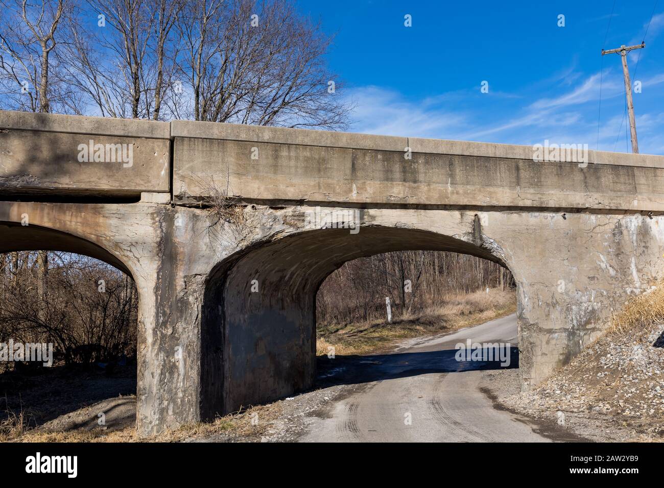 Vecchio ponte ferroviario rurale con sbriciolamento, cracking cemento. Concetto di deterioramento delle infrastrutture di trasporto negli Stati Uniti d'America Foto Stock