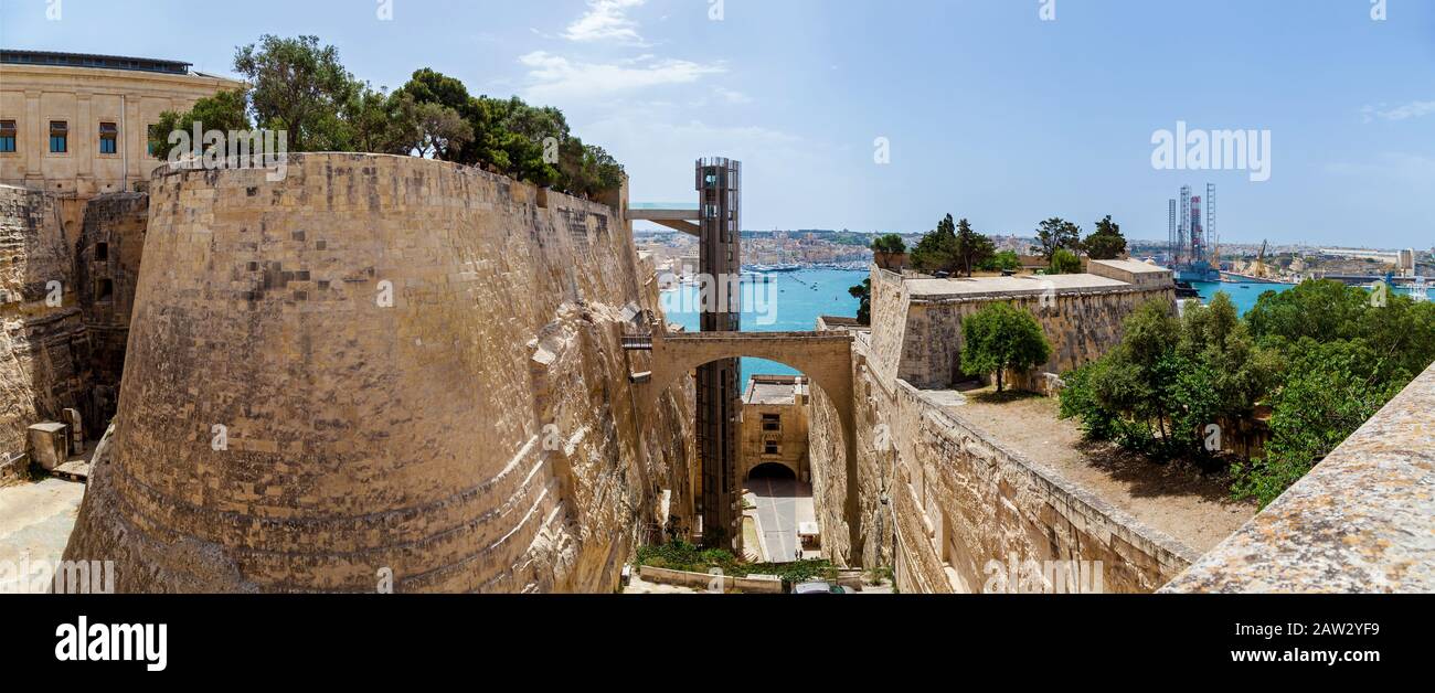 Un vecchio ascensore si trova all'interno del fosso delle fortificazioni di Valletta in una giornata estiva di sole. Foto Stock