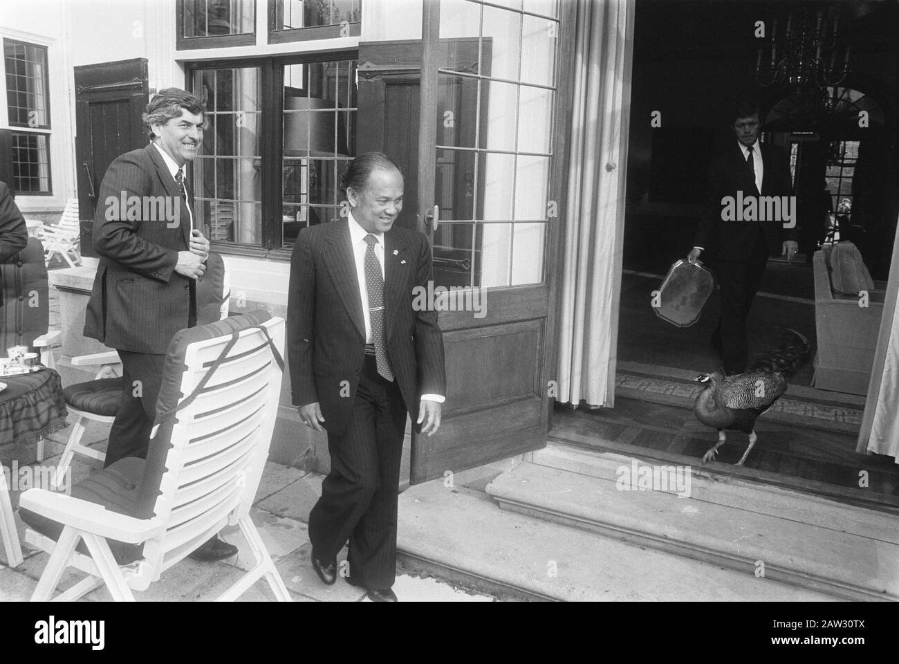 Il Premier Lubbers riceve il ministro indonesiano della tecnologia Habibie presso la residenza del primo ministro Lubbers (L) e il ministro Habibie nel giardino della residenza del primo ministro. A destra il custode con un vassoio un pavone dalla residenza del primo ministro Data: 6 giugno 1983 luogo: L'Aia, Sud Olanda Parole Chiave: Ministri, primi ministri, visite di stato, giardini Nome Persona: Habibie, Bacharuddin Jusuf, Lubbers, Ruud Foto Stock