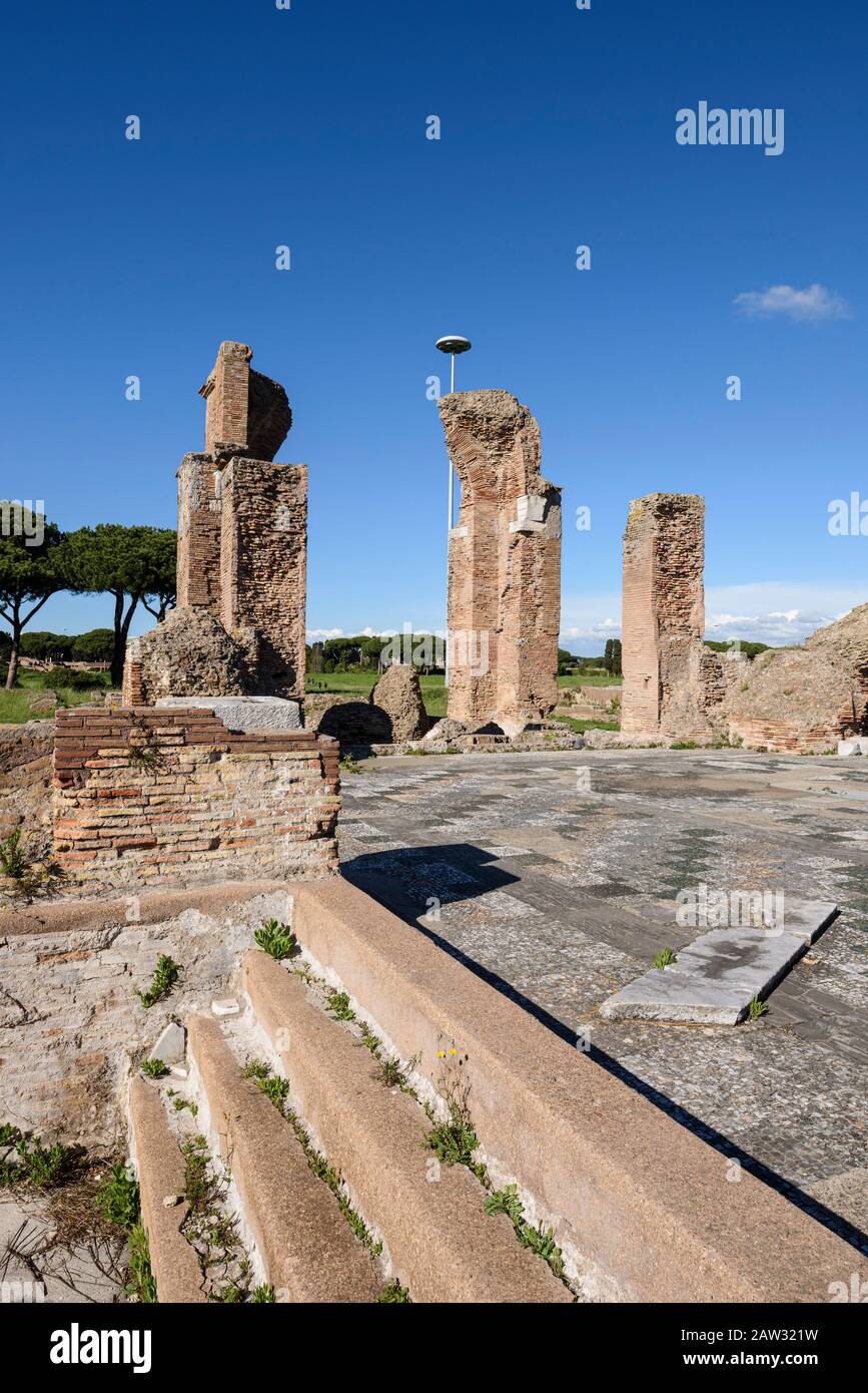 Roma. Italia. Ostia Antica. Terme di porta Marina (Terme di porta Marina). Pieri di mattoni dell'abside, gradini che conducono al frigidarium, il pavimento è dec Foto Stock