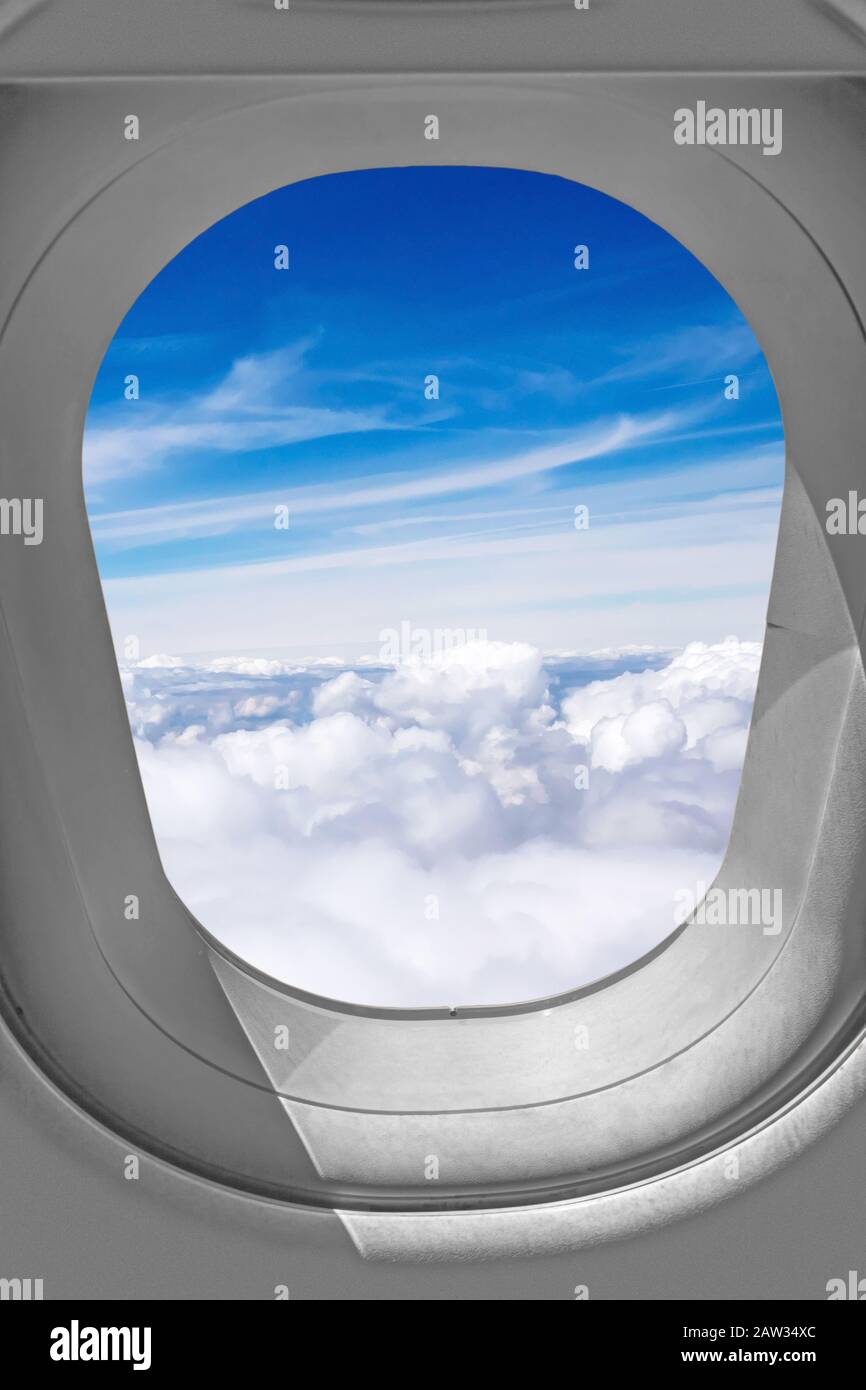 Vista attraverso la finestra dell'aeroplano, cielo sopra le nuvole Foto Stock