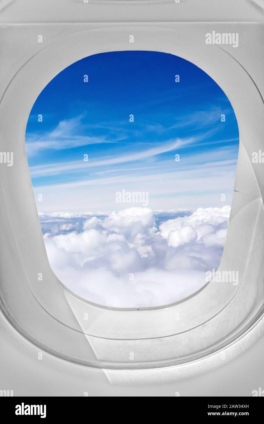 Vista attraverso la finestra dell'aeroplano, cielo sopra le nuvole Foto Stock