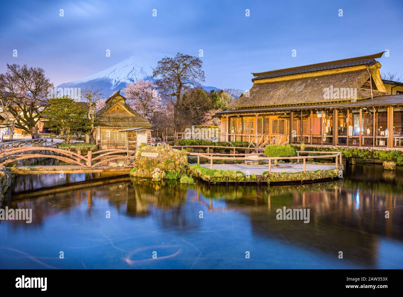 Oshino, Giappone storico tetto di paglia case coloniche con Mt. Fuji al crepuscolo. Foto Stock