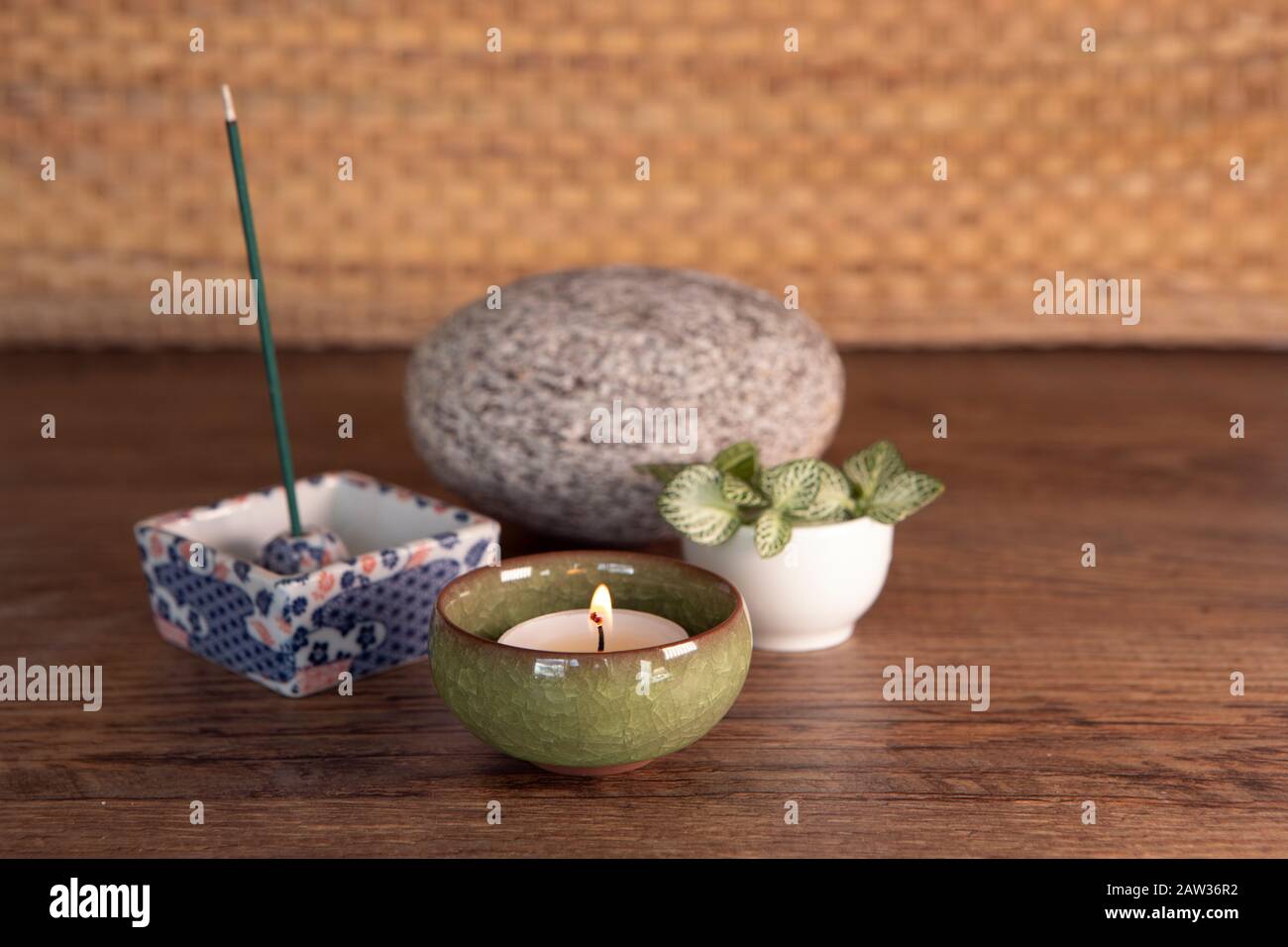 Smoking e smoking joss, luce candela, pietra, foglie fresche su sfondo di legno. Wellbiing, yoga, attrezzature per meditazione. Foto Stock