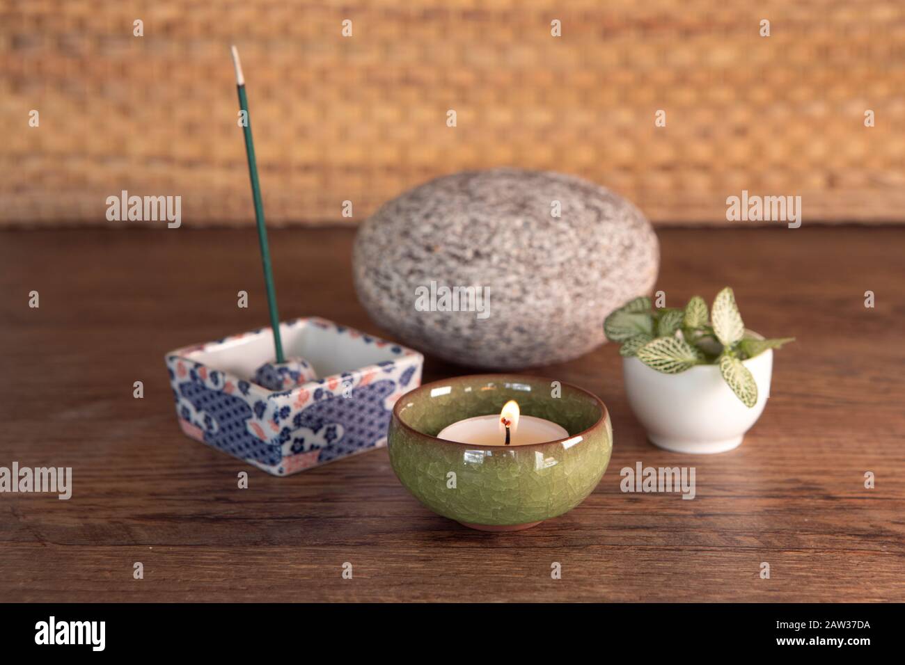 Bastoncino di joss fumante e profumato, candela con fiamma, sfondo di legno. Wellbiing, yoga, attrezzature per meditazione. Disposizione di Wellnes. Candela bruciante in un Foto Stock