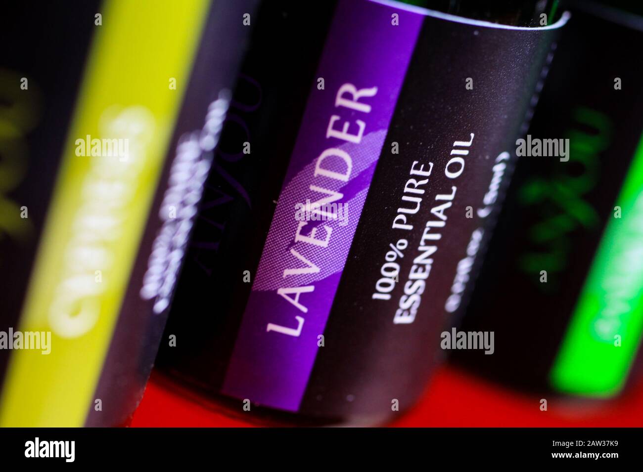 Primo piano di bottiglie di vetro con 100% di olio essenziale, lavanda sulla messa a fuoco Foto Stock