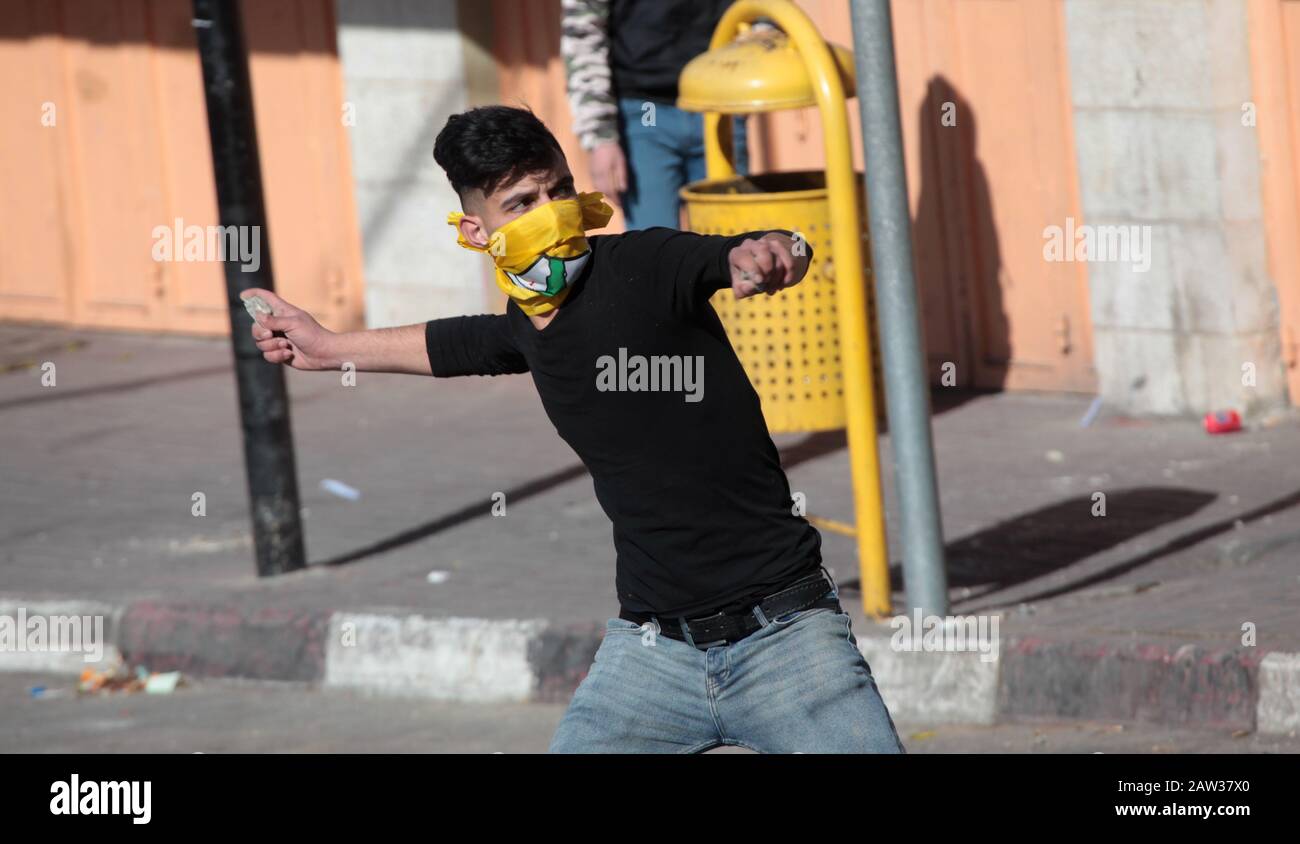 (200206) -- HEBRON, 6 febbraio 2020 (Xinhua) -- UN protestante palestinese fa scagliare pietre contro i soldati israeliani durante gli scontri nella città di Hebron, 6 febbraio 2020. (Foto Di Mamoun Wazwaz/Xinhua) Foto Stock