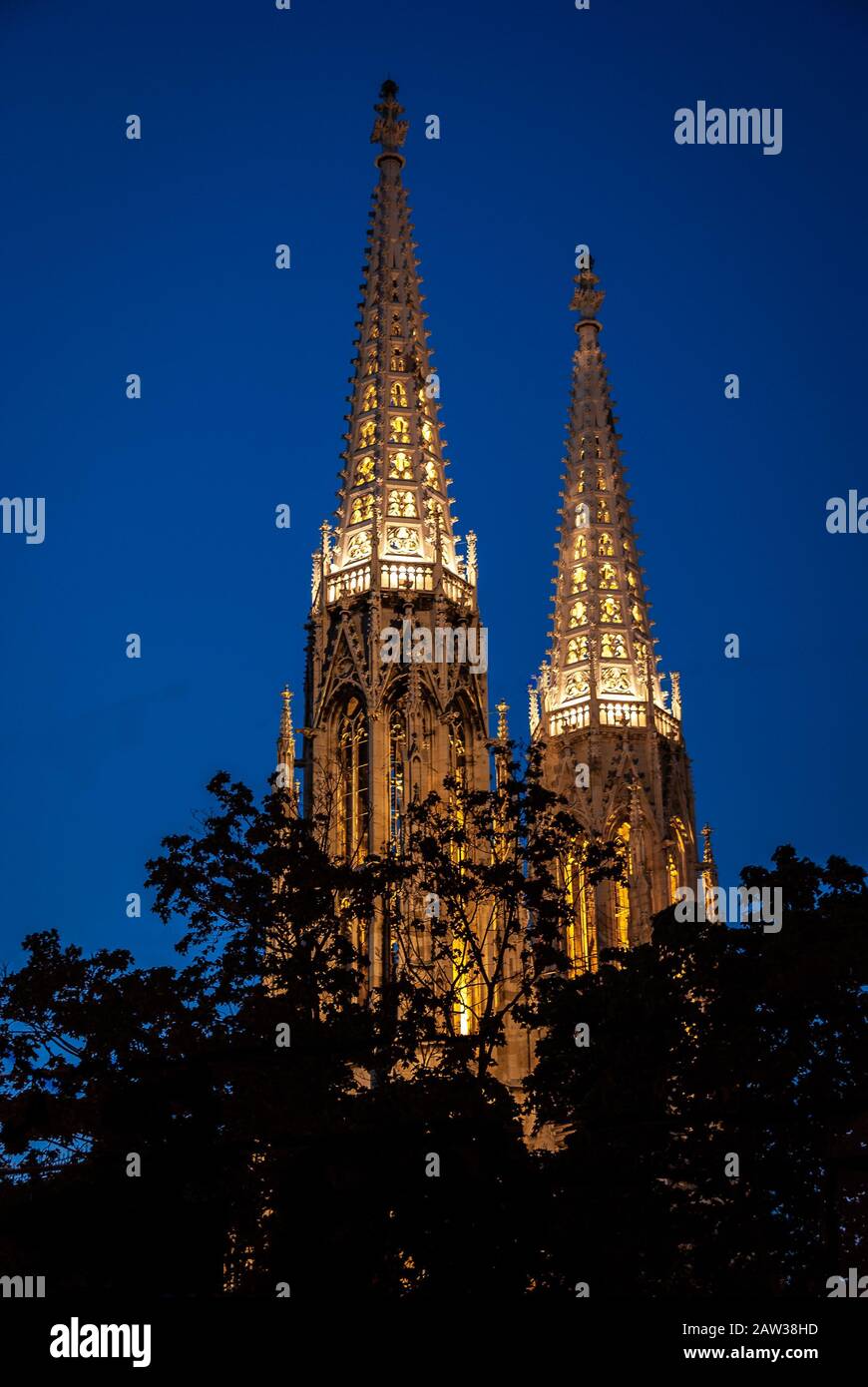 Famosa Chiesa Votiva neogotica (Votivkirche) di notte nell'ora blu di Ringstrasse - seconda chiesa più alta di Vienna, Austria. Chiesa consacrata Foto Stock