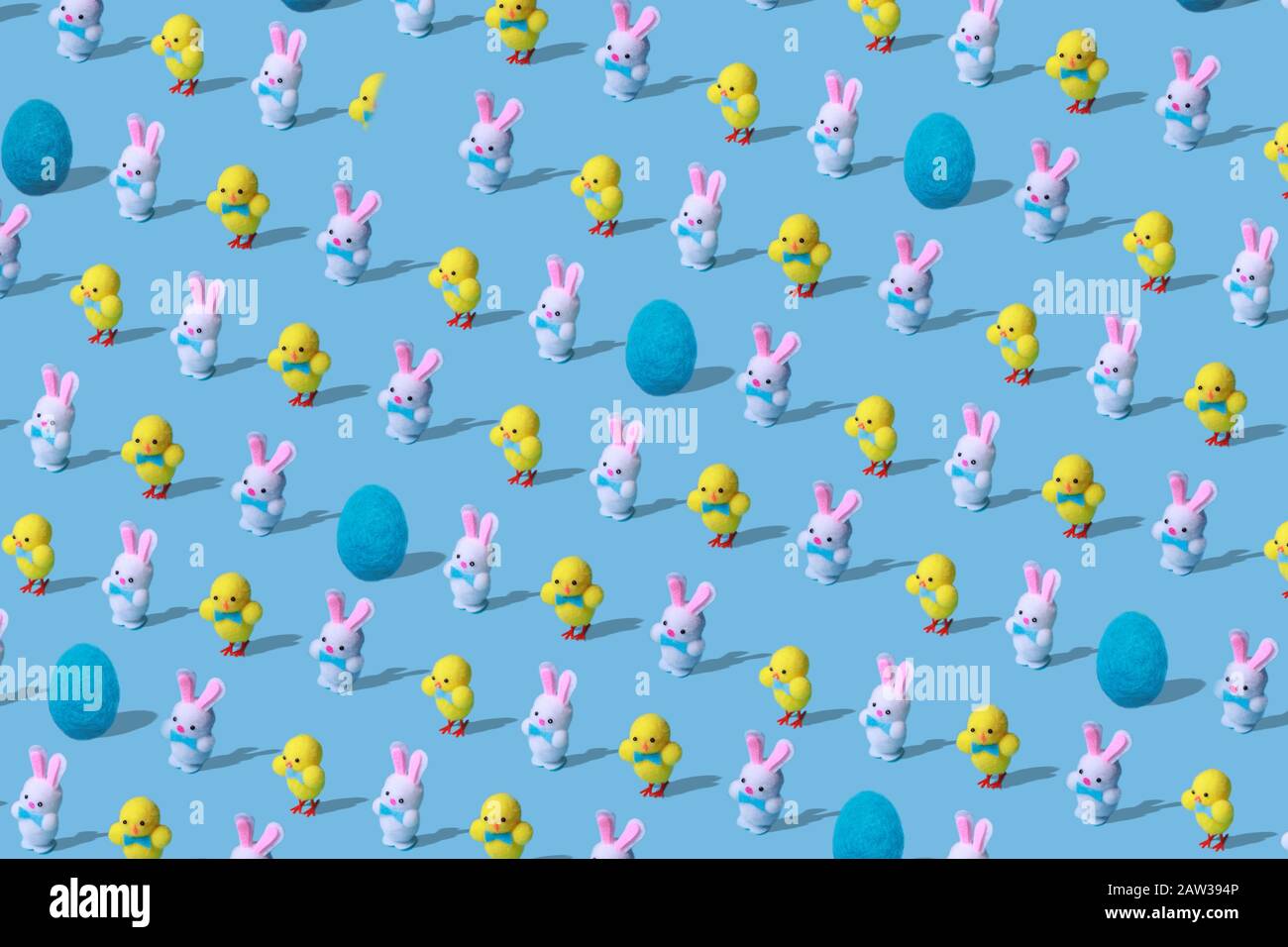 Modello di Pasqua alla moda fatto di lepri conigli, pollo e giocattoli di lana d'uovo su sfondo blu in stile minimal. Concetto di Pasqua in stile minimale. Foto Stock