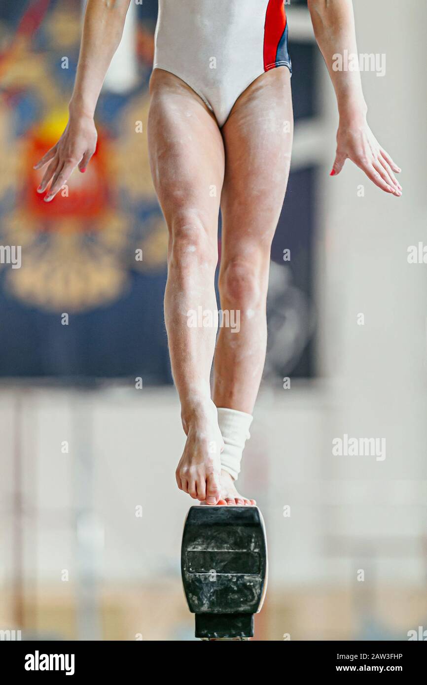 piedi ragazza ginnastica sul fascio di equilibrio in ginnastica Foto Stock