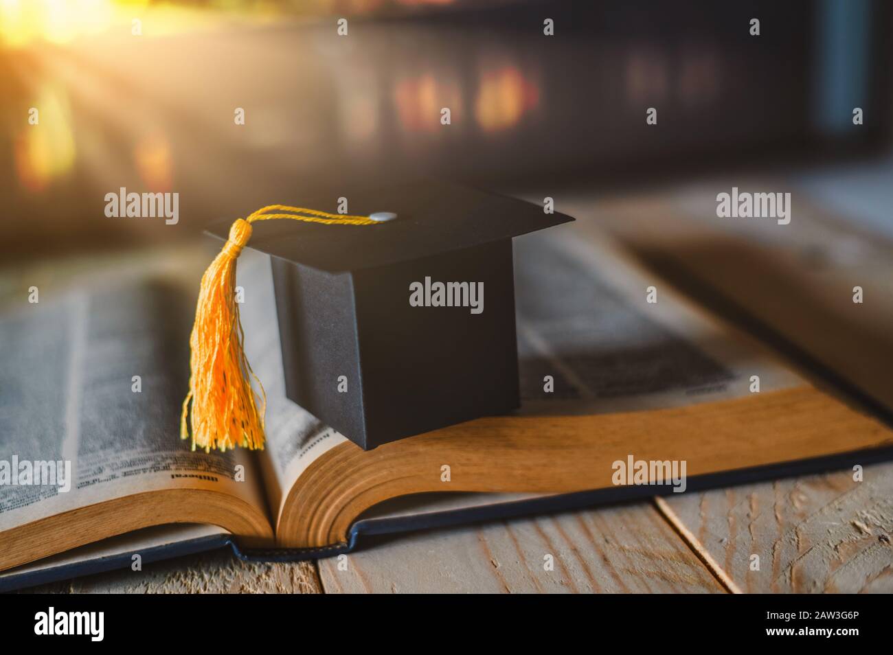 Studio di apprendimento universitario o di formazione all'estero concetto: Limite di laurea su libro di testo di apertura in vecchia biblioteca Foto Stock